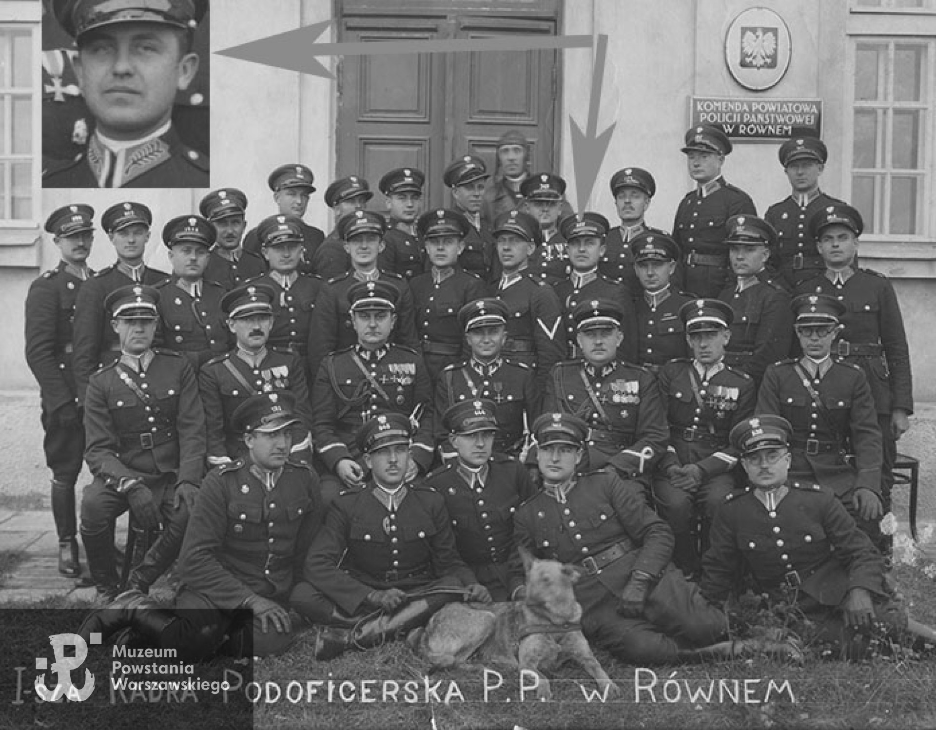 Edward Walenty  Dembek - fotografia wykonana przed wojną  podczas służby w  Policji  Państwowej w Równem. W tle widoczny budynek Komendy Powiatowej Policji Państwowej w Równem.  Fot. z archiwum rodzinnego udostępnił bratanek, p.  Stanisław Dembek