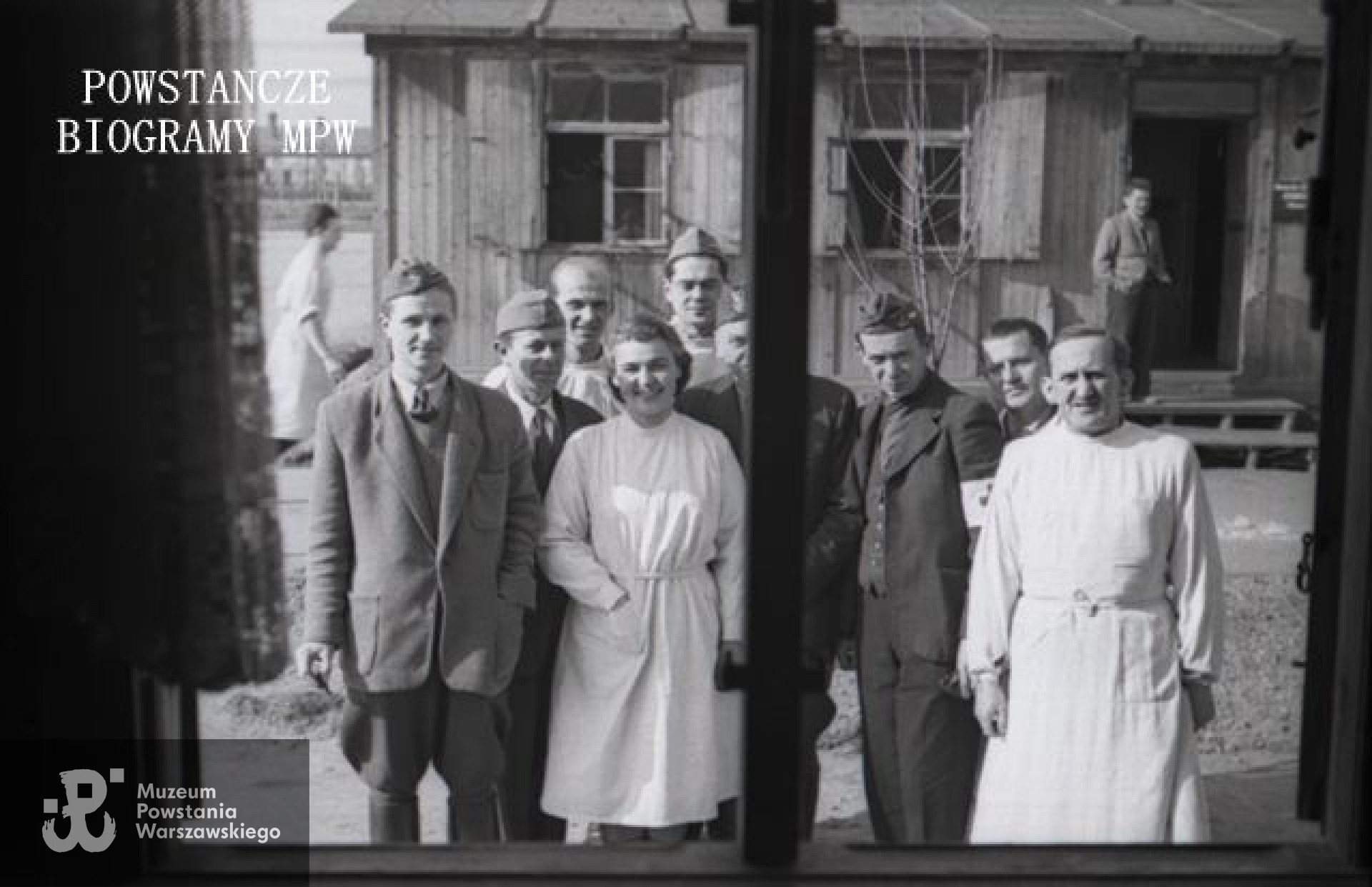 Fotografia z Polskiego Szpitala Wojskowego w saksońskim Zeithain. Czwarta od lewej kpt. dr Jadwiga Beaupré „Malina” , dalej student medycyny kpr. pchor. Mirosław (Mark) Ferster „Mirosław” ppłk dr Tadeusz Bętkowski „Tata” (częściowo zasłonięty), dr Marian Mroczkowski, NN, dr Mieczysław Zapolski. Ujęcie przez okno, z wnętrza baraku. Fot. Czesław Gerwel "Orłoś".  Ze zbiorów Fototeki Muzeum Powstania Warszawskiego sygn. <a href=" http://www.1944.pl/galerie/fototeka/foto/4414/ "> MPW-IN/3846 </a>