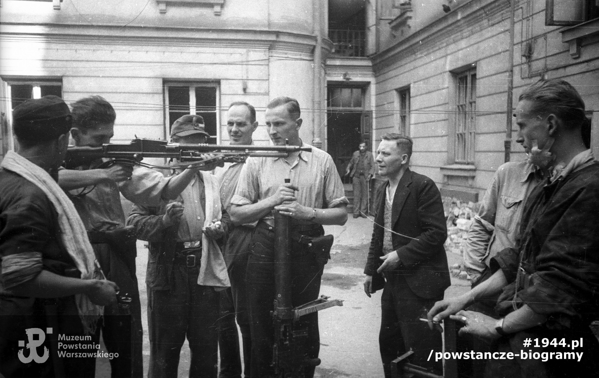  Śródmieście Północne. Podwórze domu przy ul. Świętokrzyskiej 20. Kpr. pchor. Włodzimierz Wiśniewski "Cygan" z kompanii "Janusza" z batalionu "Harnaś" pokazujący kolegom czechosłowacki ręczny karabin maszynowy ZB wz. 1926 zdobyty po ataku na Komendę Policji. W środku stoi plut. pchor. Adam Podkóliński "Michał", „Olszewski” (w jasnej koszuli) z opartym o ziemię niemieckim lekkim karabinem maszynowym leMG 08/15. Powstaniec na pierwszym planie po prawej trzyma brytyjski granatnik przeciwpancerny PIAT. Fot. ze zbiorów Muzeum Powstania Warszawskiego, sygn. MPW-IN/10210. Autorem zdjęcia jest Joachim Joachimczyk "Joachim"
 
