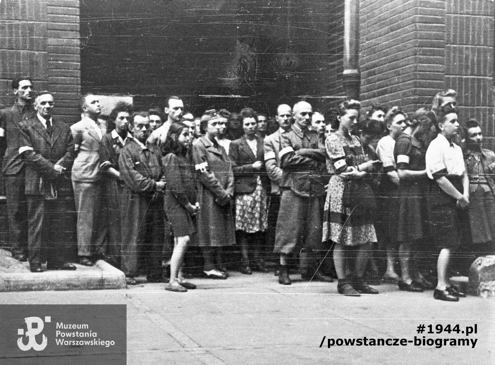 Fotografia z Powstania Warszawskiego. Msza polowa w podwórzu budynku przy ulicy Poznańskiej 12, kwaterze dowództwa zgrupowania "Zaremba" i kompanii "Witolda". Autorem zdjęcia jest Stanisław Dobrzyński. Fot. ze zbiorów Muzeum Powstania Warszawskiego, sygn. MPW-IH/1828. Według identyfikacji rodzinnej pierwsza z prawej (w białej bluzce z opaską)  stoi Janina Gerarda Mesterhazy. Za nią pod murem (szósta od prawej) Hanna Jaśkiewicz po mężu Kowalska.