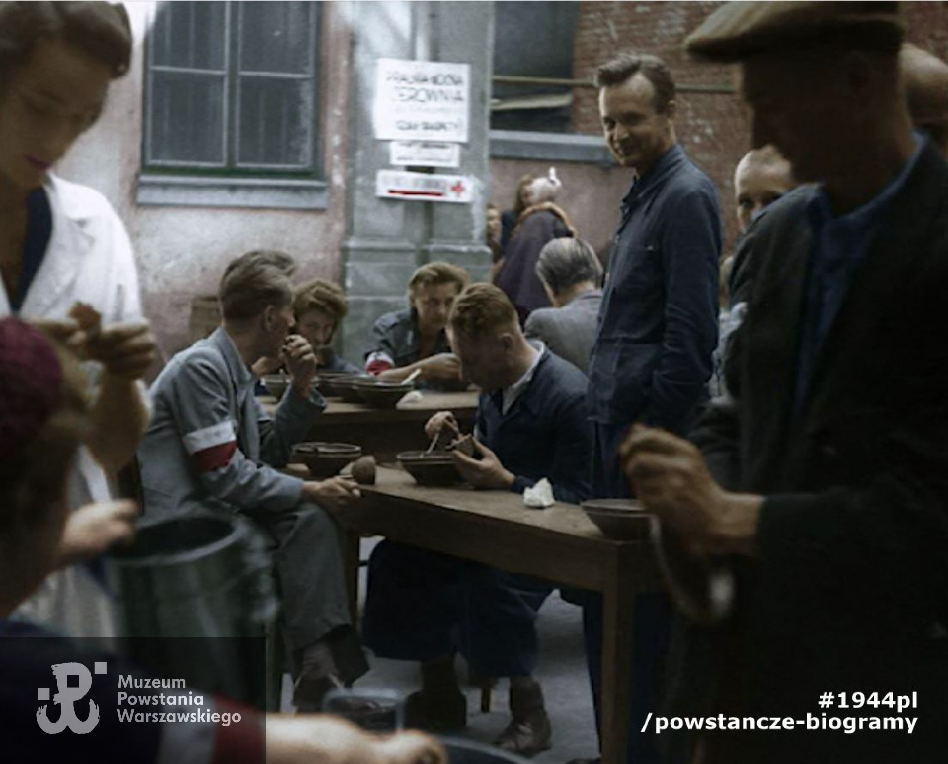 Stołówka powstańcza na podwórzu kamienicy przy ul. Szpitalnej 8. W środku por. Józef Marian Sosnowski, ps. Brzeziński. Zdjęcie filmowe z okresu Powstania. Ze zbiorów Muzeum Powstania Warszawskiego