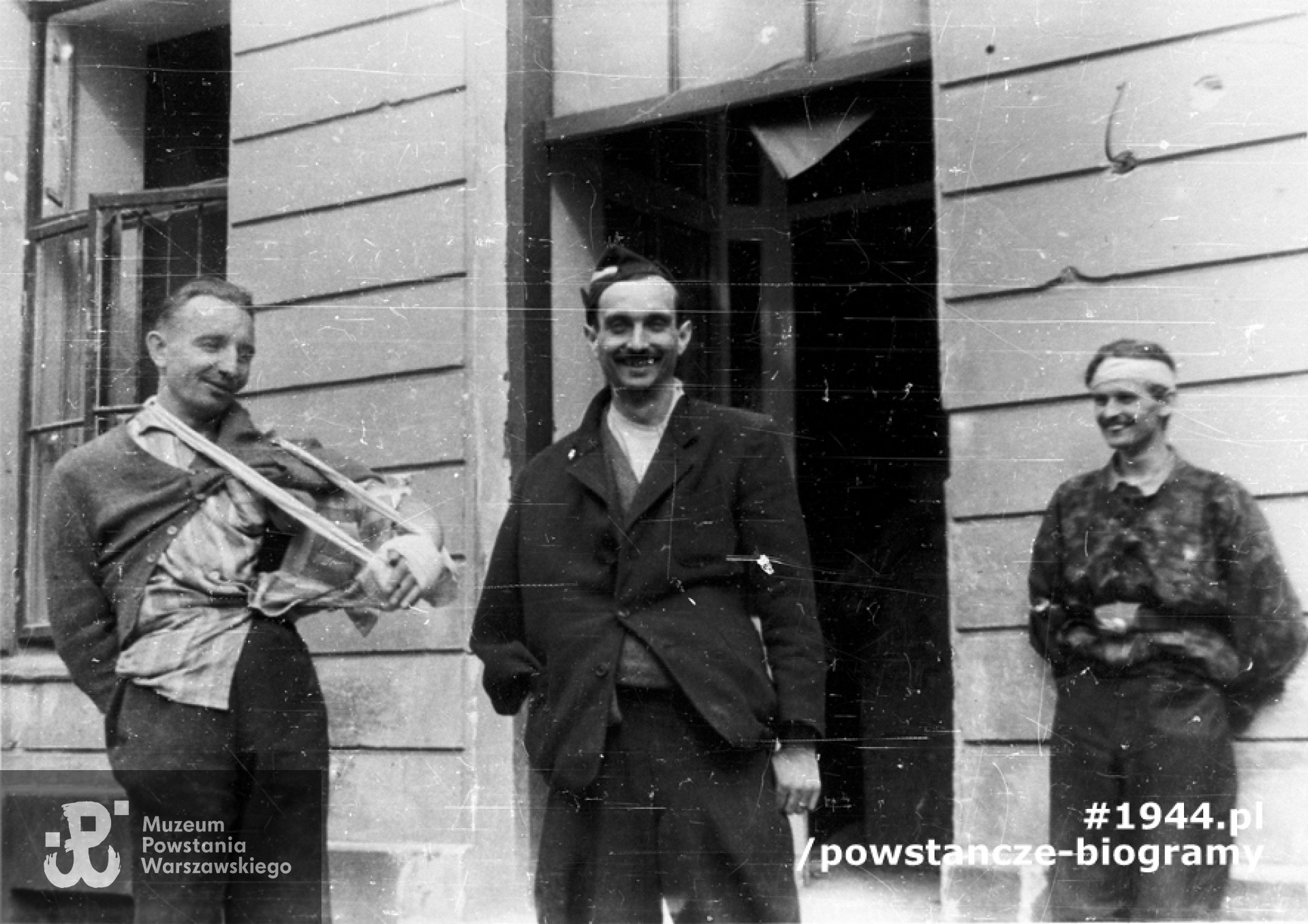 Fotografia z Powstania Warszawskiego. Śródmieście Południowe, ul. Śniadeckich. Ranni żołnierze batalionu "Chrobry I" przed szpitalem na ul. Śniadeckich 17 (ewakuowany z ul. Senatorskiej Szpital Maltański). Od lewej: ppor. Eugeniusz Glass - Brudziński "Marek", por. Tadeusz Kajetański "Edward Czarnocki", kpr. pchor. Stanisław Ptaszyński "Skała". Autorem zdjęcia jest  Zygmunt Sowiński "Ostoja". Fot.  ze zbiorów Muzeum Powstania Warszawskiego, sygn. MPW-IN/8753