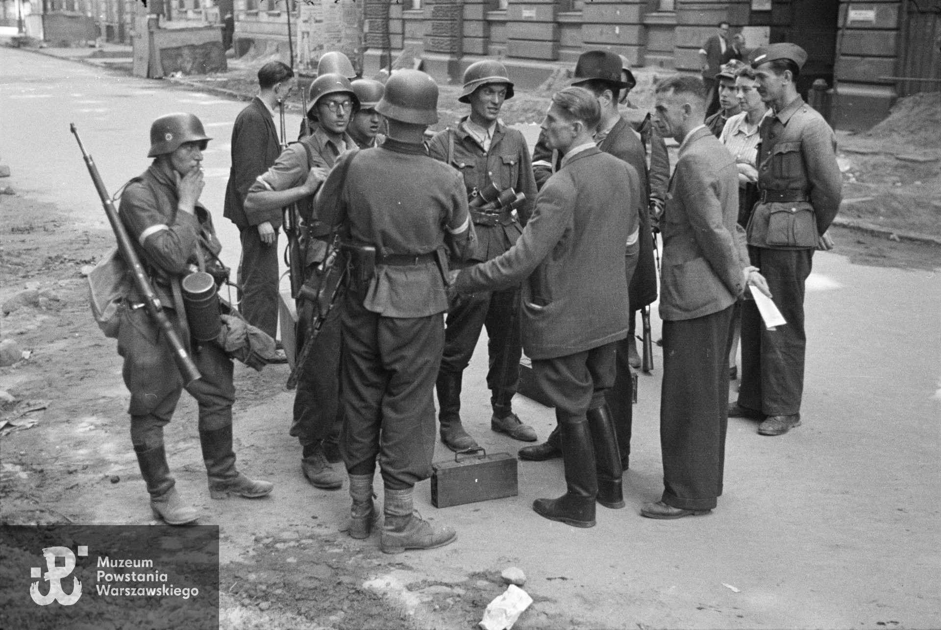Śródmieście Północne. Grupa Powstańców z kompanii "Koszta" na ulicy Moniuszki; od lewej: kpr. Andrzej Ferencowicz "Siuchaj", st. strz. Tadeusz Suliński "Radwan", plut. pchor. Jerzy Tyczyński "Jur"; tyłem stoją: plut. pchor. Włodzimierz Radajewski "Rataj", por. Roman Rozmiłowski "Zawada". Fot. autorstwa Eugeniusza Lokajskiego ps. "Brok". Ze zbiorów Muzeum Powstania Warszawskiego, sygn. MPW-IN/717.