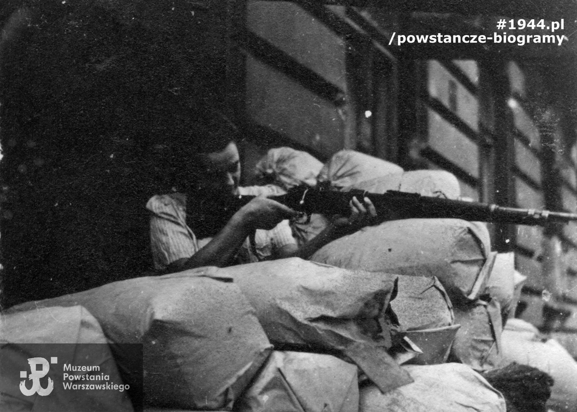 Fotografia z Powstania Warszawskiego: żołnierze z plutonu "Skobiga". Na barykadzie Zofia Godlewska "Zosia". Fot. ze zbiorów Muzeum Powstania Warszawskiego MPW-IH/5097