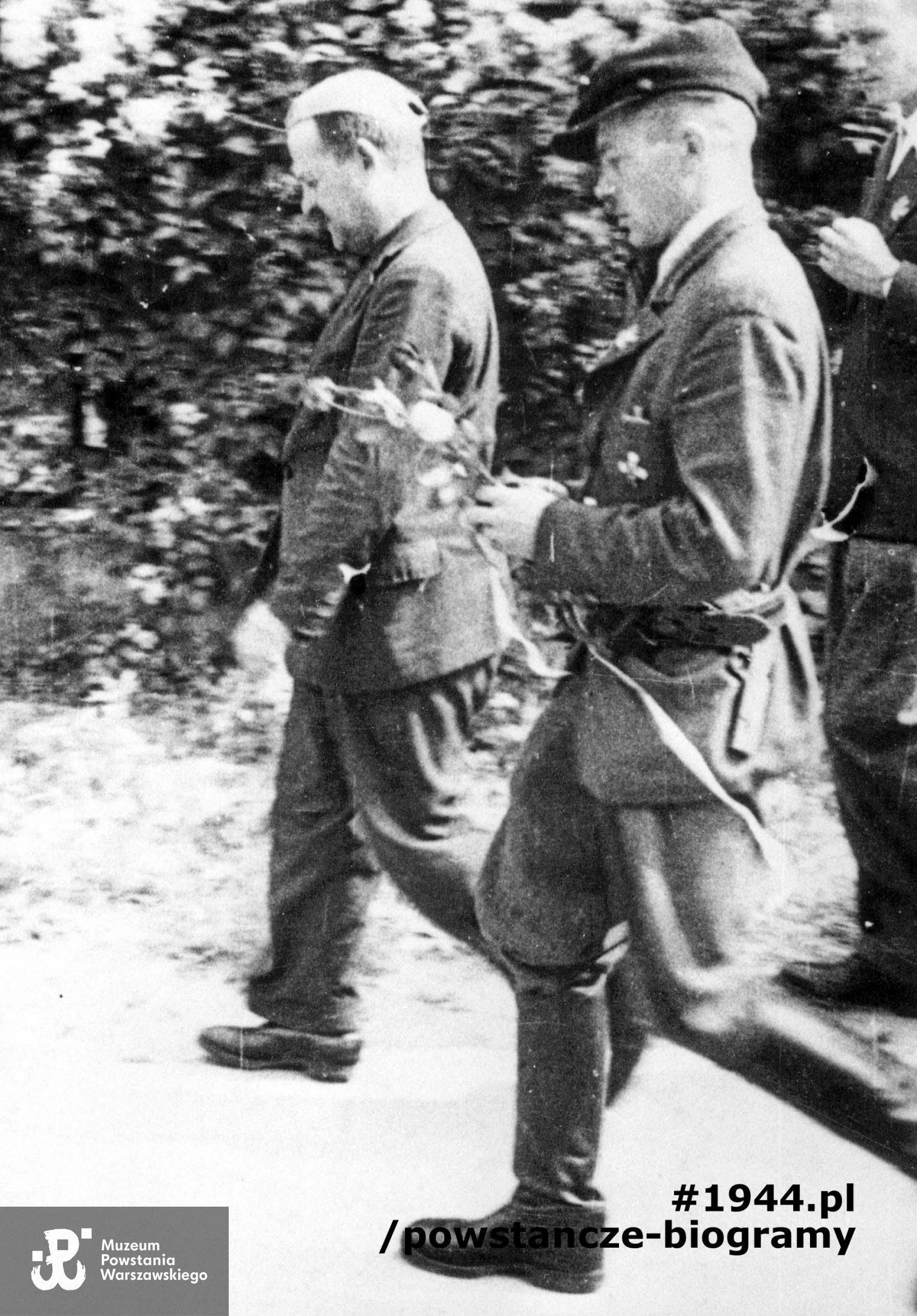 Fotografia z Powstania Warszawskiego. Żoliborz. Od lewej ppłk Mieczysław Niedzielski "Żywiciel" i kpt. Marian Kamiński "Żaglowiec" "Jur" z wiązanką kwiatów po nabożeństwie odprawionym 18 sierpnia w domu przy Pogonowskiego 22. Fot. ze zbiorów Muzeum Powstania Warszawskiego, sygn. MPW-IH/5124