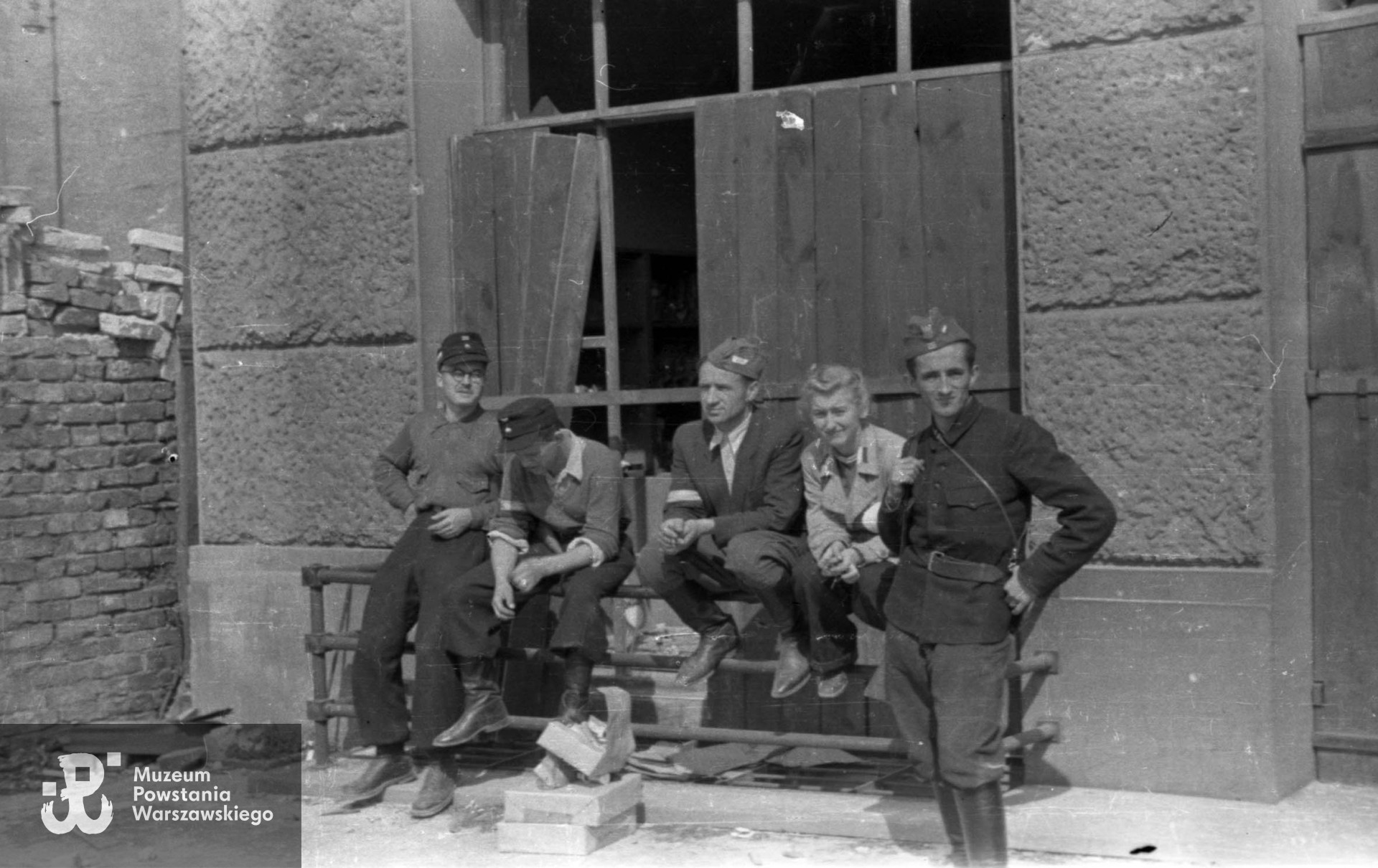 Grupa żołnierzy z pułku NSZ im. gen. Władysława Sikorskiego w podwórzu Domu Technika przy ul. Czackiego 3/5. Od lewej: kpr. pchor. Henryk Dutkowski "Kosowski", NN, por. rez. Władysław Rutkowski "Włodzimierz Jan", sanitariuszka NN, kpr. pchor. Stanisław Wład "Tarnowski". Autorem zdjęcia jest Jerzy Kokczyński "Boczkowski". Fot. ze zbiorów Muzeum Powstania Warszawskiego,  sygn. MPW-IN/3467
