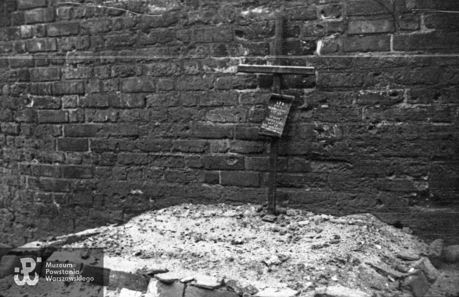 Okres powojenny. Warszawa. Powstańczy grób łączniczki Ewy Faryaszewskiej i kpr. pchor. Leszka Świderskiego na tzw. Międzymurzu na Starym Mieście. Zdjęcie wykonane między 19 - 21 stycznia 1945 r., autorem jest Eugeniusz Haneman. Ze zbiorów Muzeum Powstania Warszawskiego, sygn. MPW-IN/2852