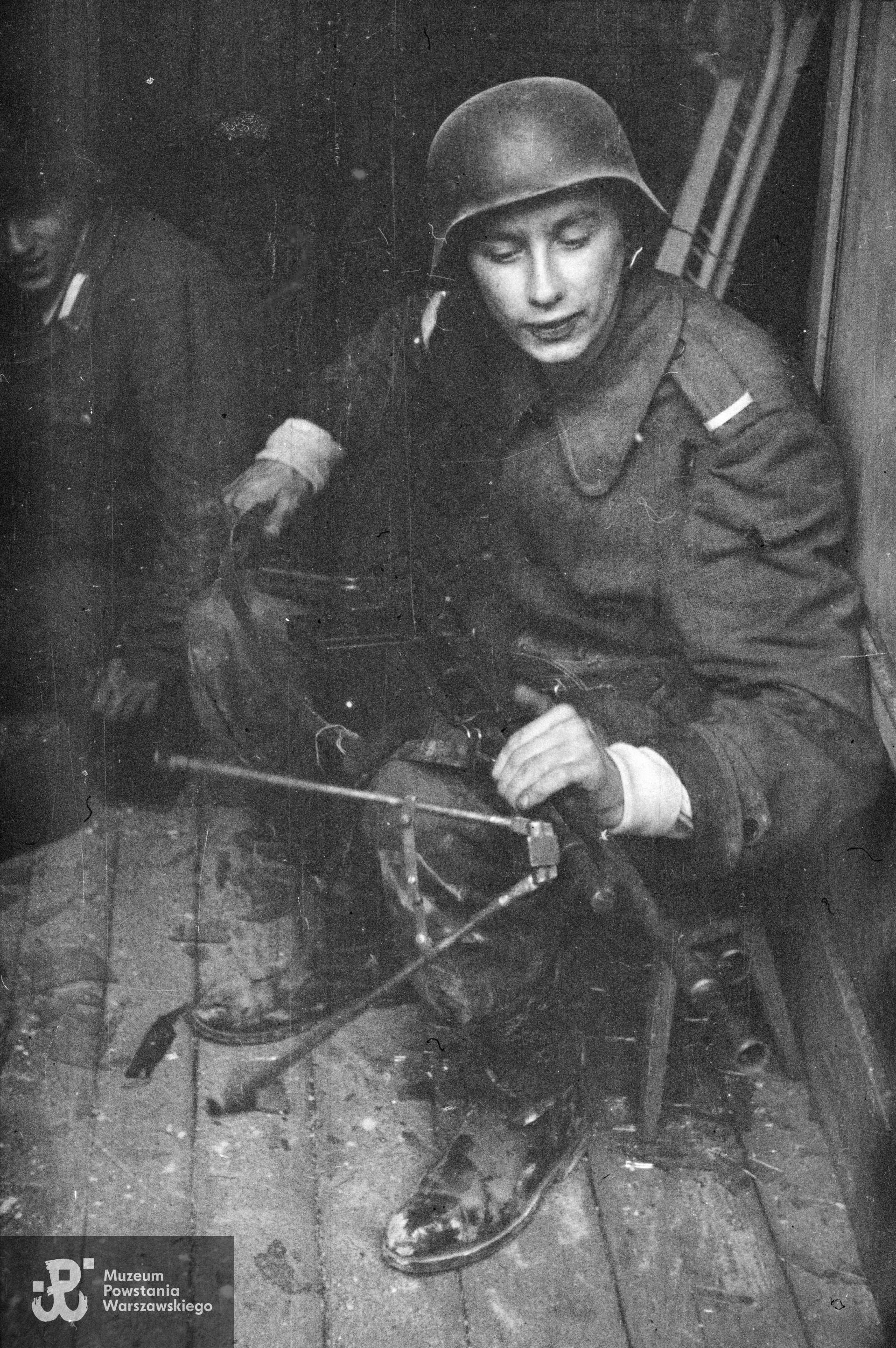 Fotografia z Powstania Warszawskiego. Śródmieście Północne. Wnętrze jednego z budynków bazaru Pociejów między ul. Zielną i Bagno. St. strz. Zbigniew Boryczka "Dzierżak" z ręcznym karabinem maszynowym Browning wz. 1928 przed atakiem na gmach PAST-y. Fot. ze zbiorów Muzeum Powstania Warszawskiego, sygn. MPW-IN/559