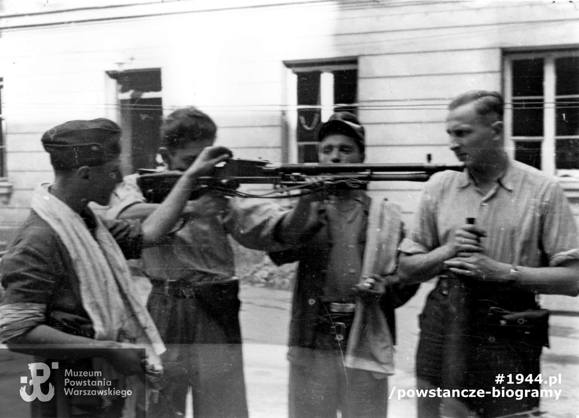 Podwórze kamienicy przy ul. Świętokrzyskiej 20. Kpr. pchor. Włodzimierz Wiśniewski "Cygan" z kompanii "Janusza" Batalionu "Harnaś" pokazujący kolegom czechosłowacki, ręczny karabin maszynowy ZB wz. 1926 zdobyty po ataku na Komendę Policji. Pierwszy od prawej plut. pchor. Adam Podkóliński "Michał", „Olszewski” trzyma zdobyczny niemiecki karabin maszynowy leMG 08/15. Fot. ze zbiorów Muzeum Powstania Warszawskiego, sygn. MPW-IN/727. Autorem zdjęcia jest Eugeniusz Lokajski "Brok".