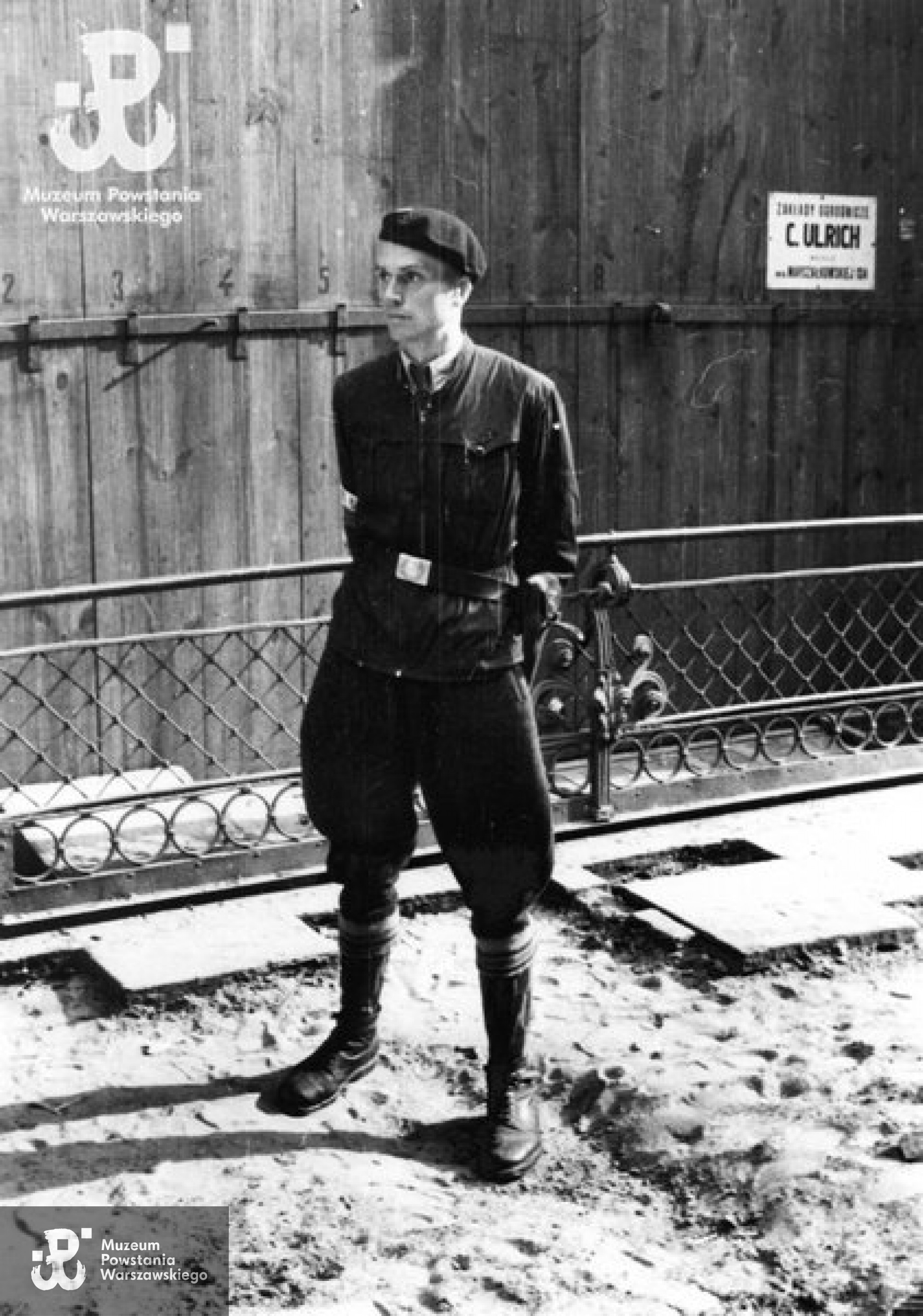 Śródmieście Północne. Ppor. Zbigniew Sas-Jaworski "Nóż" ze Sztabu Obszaru Warszawa AK przed sklepem ogrodniczym "Ulrich" w kamienicy przy ulicy Moniuszki 11 róg Marszałkowskiej 124/128 (budynek dawnego Towarzystwa Ubezpieczeniowego "Rosja"). Fot. autorstwa Eugeniusza Lokajskiego ps. "Brok" ze zbiorów Fototeki MPW, sygn. MPW-IN/194
