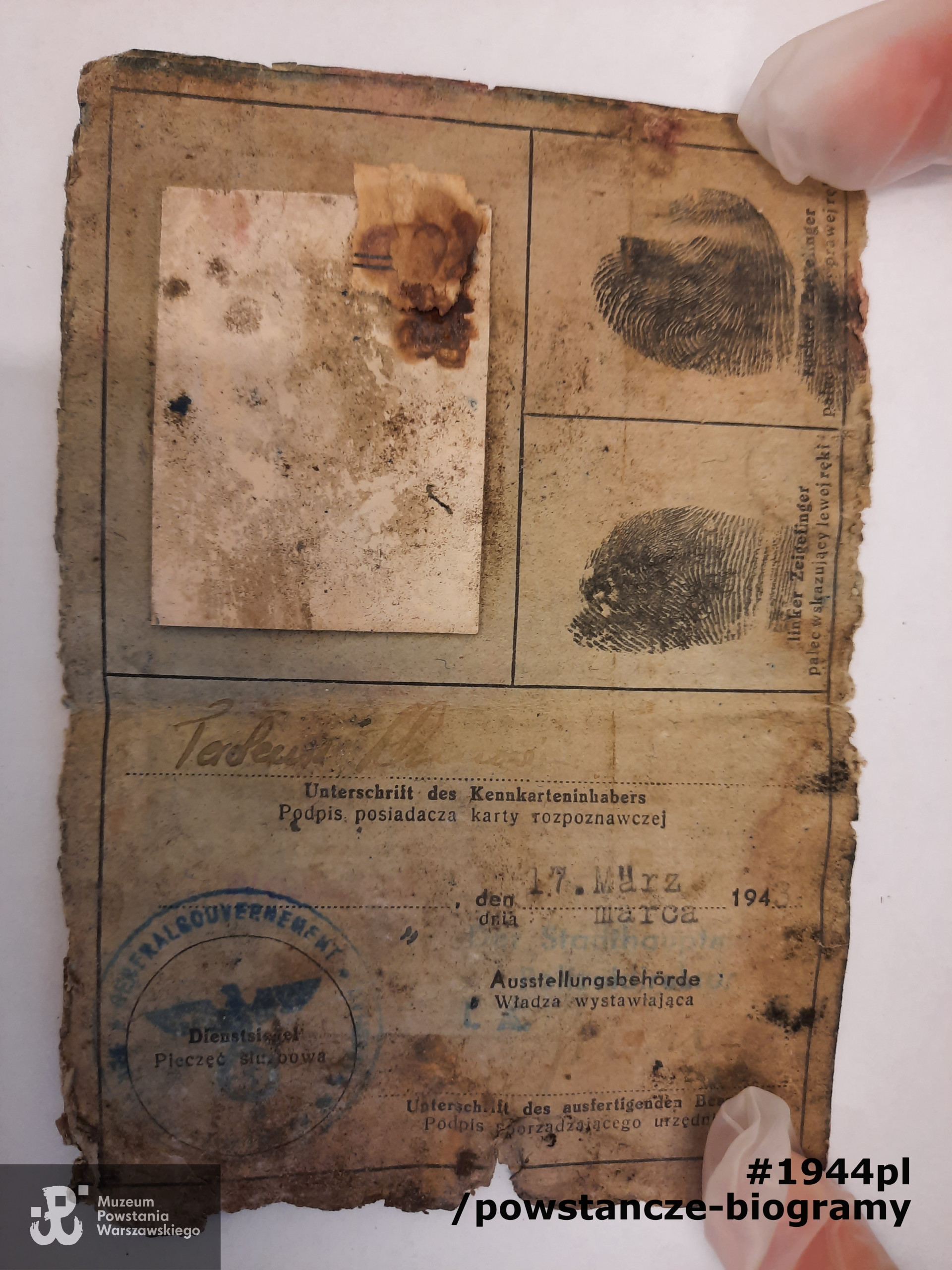 Kennkarta  Tadeusza Klimowicza (dwie strony). Niezachowana strona z danymi osobowymi. Fotografia nieczytelna, Częściowo widoczny podpis właściciela. Ze zbiorów Muzeum Powstania Warszawskiego, sygn. P/9581/21