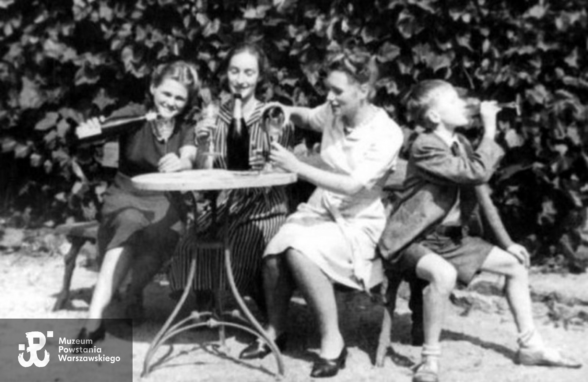 Teresa Iwaszkiewicz, Krystyna Żochowska, Maria Iwaszkiewicz i Marek Piątkowski na Stawisku podczas wojny. Lemoniada udaje wino. <i>Fot. Archiwum rodzinne, źródło wysokieobcasy.pl</i>