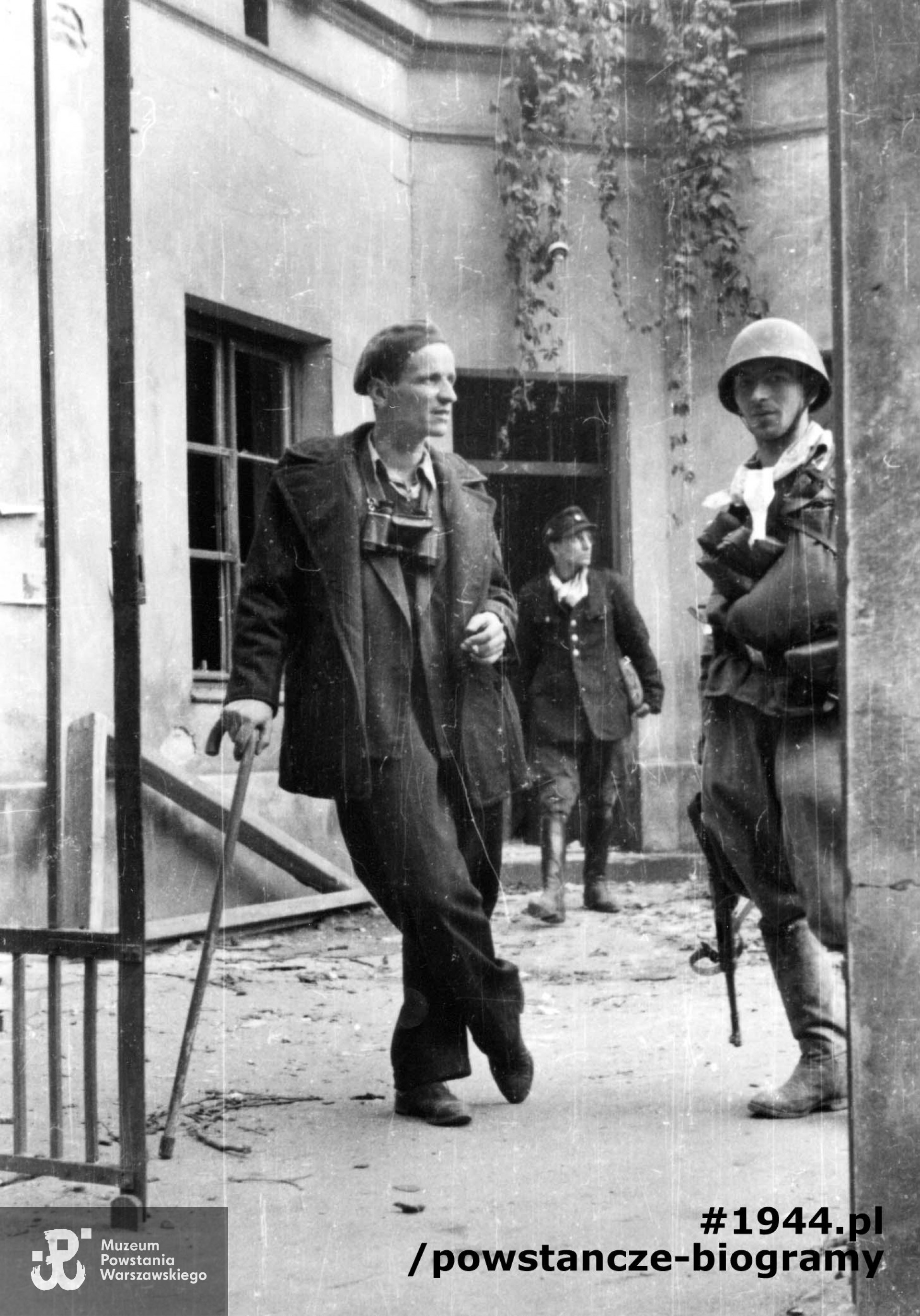 Fotografia z Powstania Warszawskiego. Śródmieście Północne. Powstańcy z kompanii "Koszta" na podwórzu jednej z kamienic. Po lewej mjr Stefan Mich "Kmita" (opierający się na lasce) wraz ze swoim adiutantem (NN), w głębi strz. Jan Gietko "Kupiec". Autorem zdjęcia jest Eugeniusz Lokajski "Brok". Fot. ze zbiorów Muzeum Powstania Warszawskiego, sygn. MPW-IN/807
