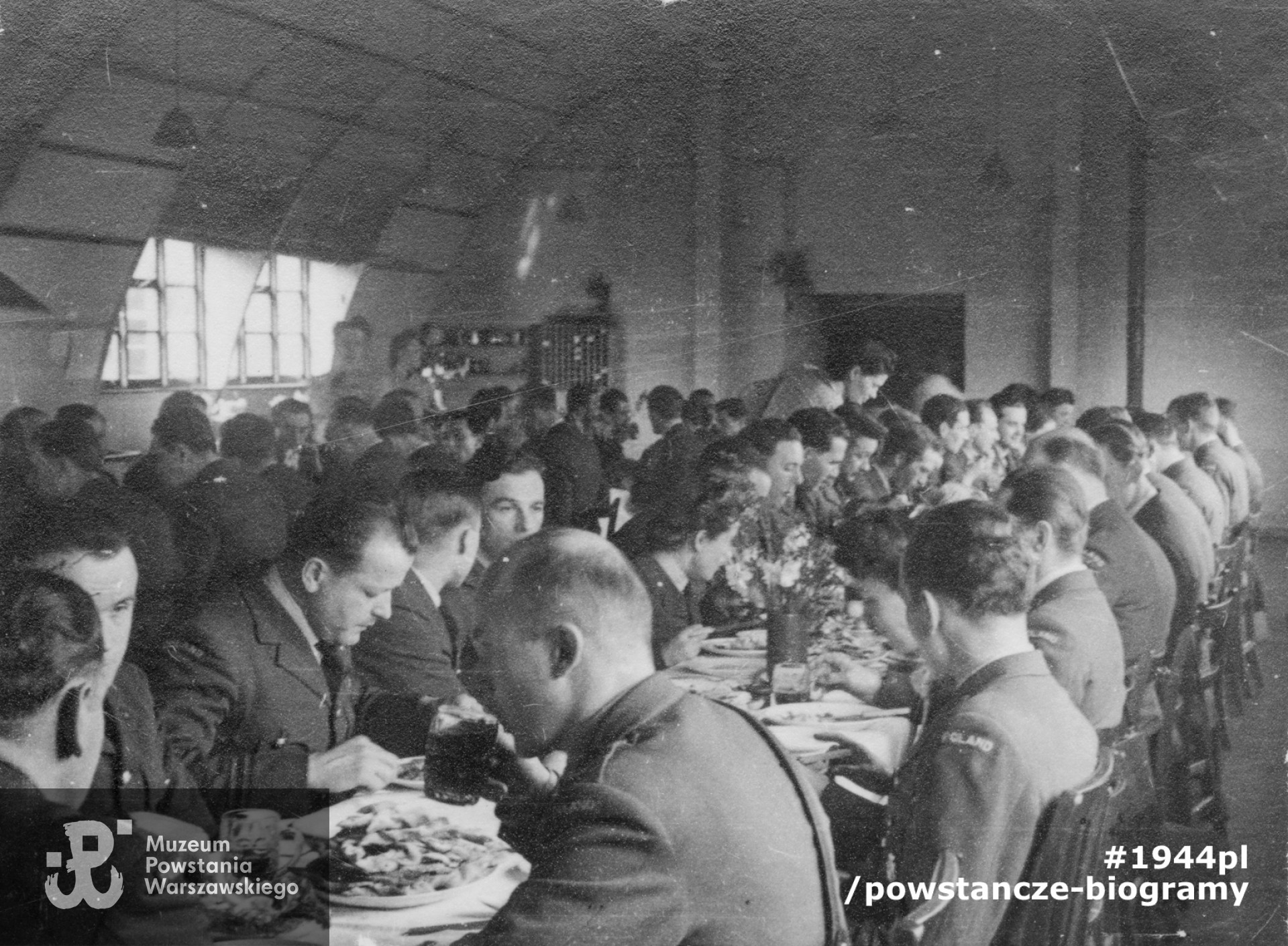 Fotografia z okresu II wojny światowej. Jan Nowak-Jeziorański (na pierwszym planie w środku), podczas uroczystego obiadu dla żołnierzy polskich. Fot. ze zbiorów Muzeum Powstania Warszawskiego, sygn.  MPW-IS/774