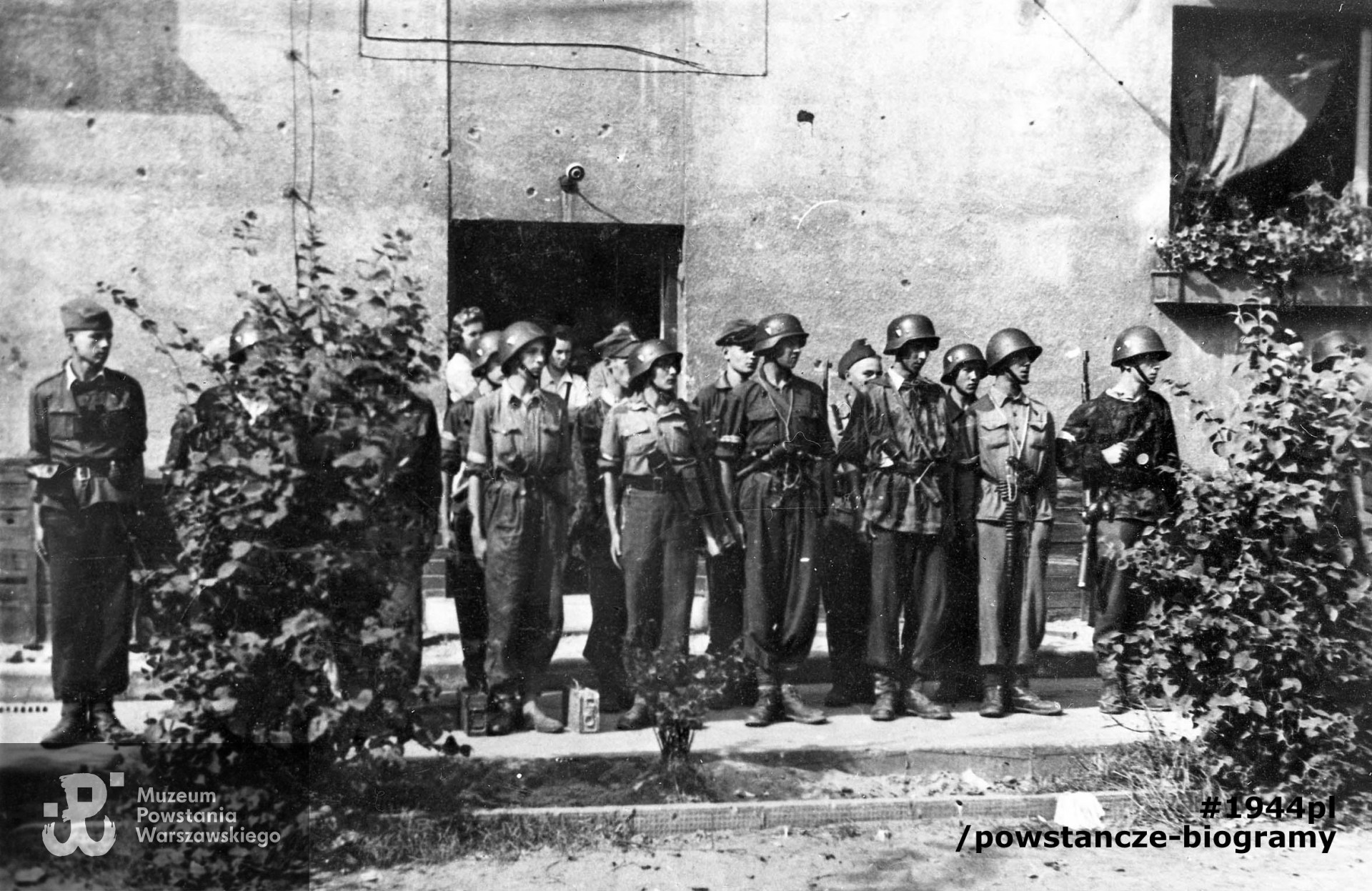 Fotografia z Powstania Warszawskiego. Żoliborz, żołnierze zgrupowania "Żyrafa". Przegląd plutonu 227, drużyna 300 na podwórzu bloku przy ul. Krasińskiego 20. W pierszym szeregu od lewej. st. strz. Andrzej Ryttel "Jędrek", strz. Andrzej Jachymczyk "Azjata", st. strz. Stefan Zadróżny "Witek", strz. Andrzej Kowalski "Sidol", strz. Jerzy Zawadowski "Tytus", st. strz. Daniel Olędzki "Kukułka", strz. Zbigniew Żochowski "Longin", strz. Ryszard Witrzenc "Wacek" i strz. Janusz Noskowski "Zbyszek". W drugim szeregu stoją: za "Azjatą" kpr. Jerzy Trybulski "Orlicz", za "Witkiem" strz. Jerzy Kostecki "Janusz", za "Tytusem" strz. Andrzej Sitkowski "Sowa", za "Kukułką" strz. Stanisław Śliwiński "Śliwa", za "Longinem" kpr. Zbigniew Augustyniak "Fifka", za "Wackiem" strz. Jerzy Sułkowski "Konduktorka". Fot. Ze zbiorów Muzeum Powstania Warszawskiego, sygn. MPW-IH/4258. Autorem zdjęcia jest Mieczysław Łokcikowski "Hanibal"