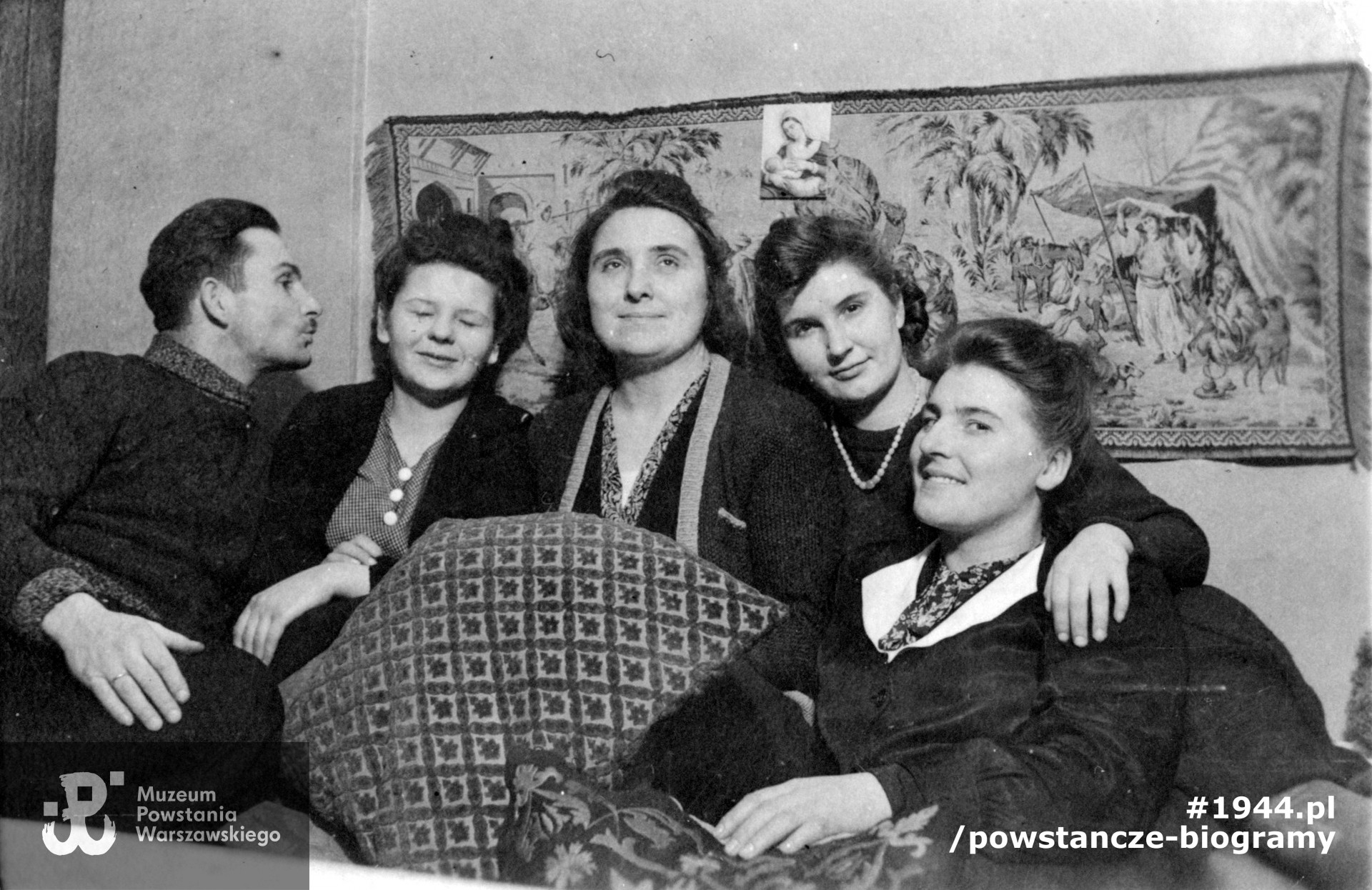 Fotografia wykonana w 1943 roku w mieszkaniu Kozaków przy ul. Widok 12, widoczni od lewej: Jerzy Kozak, mąż Haliny, Halina Etminis - Kozak, znajome. Fot. ze zbiorów Muzeum Powstania Warszawskiego, dar p. Barbary Ajnenkiel
