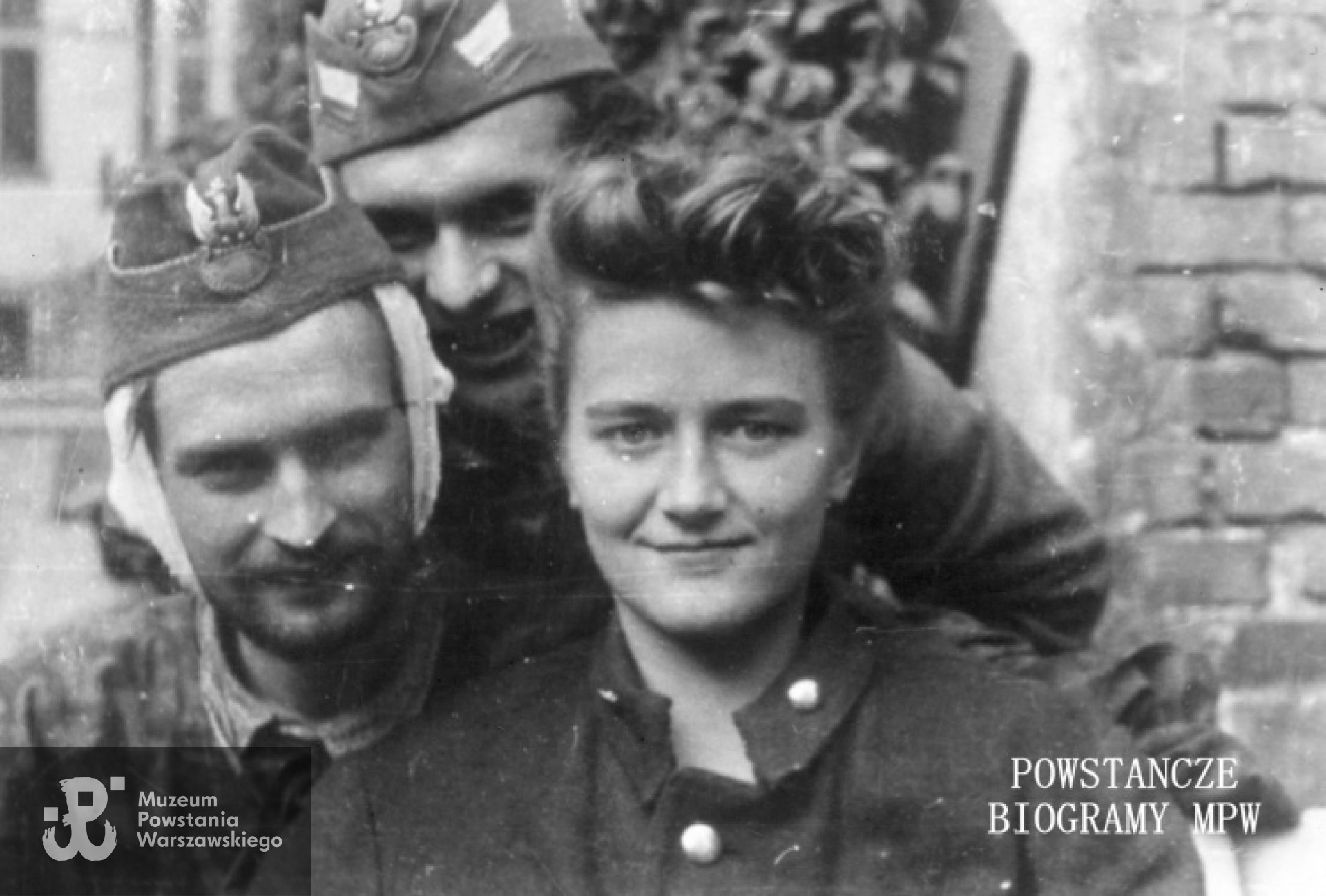 Fotografia z Powstania Warszawskiego. Śródmieście Południowe, ul. Śniadeckich. Ranni żołnierze batalionu "Chrobry I" w szpitalu na ul. Śniadeckich 17 (ewakuowany z ul. Senatorskiej Szpital Maltański). Od lewej: pchor. Stanisław Ptaszyński "Skała", strz. Władysław Wiśniewski"Kawka", łączniczka dowódcy 1. plutonu  I Kompanii Szturmowej -  Krystyna Zapaśnik "Krystyna". Autor fot. Zygmunt Sowiński "Ostoja". Ze zbiorów Muzeum Powstania Warszawskiego, sygn. MPW-IP/7207