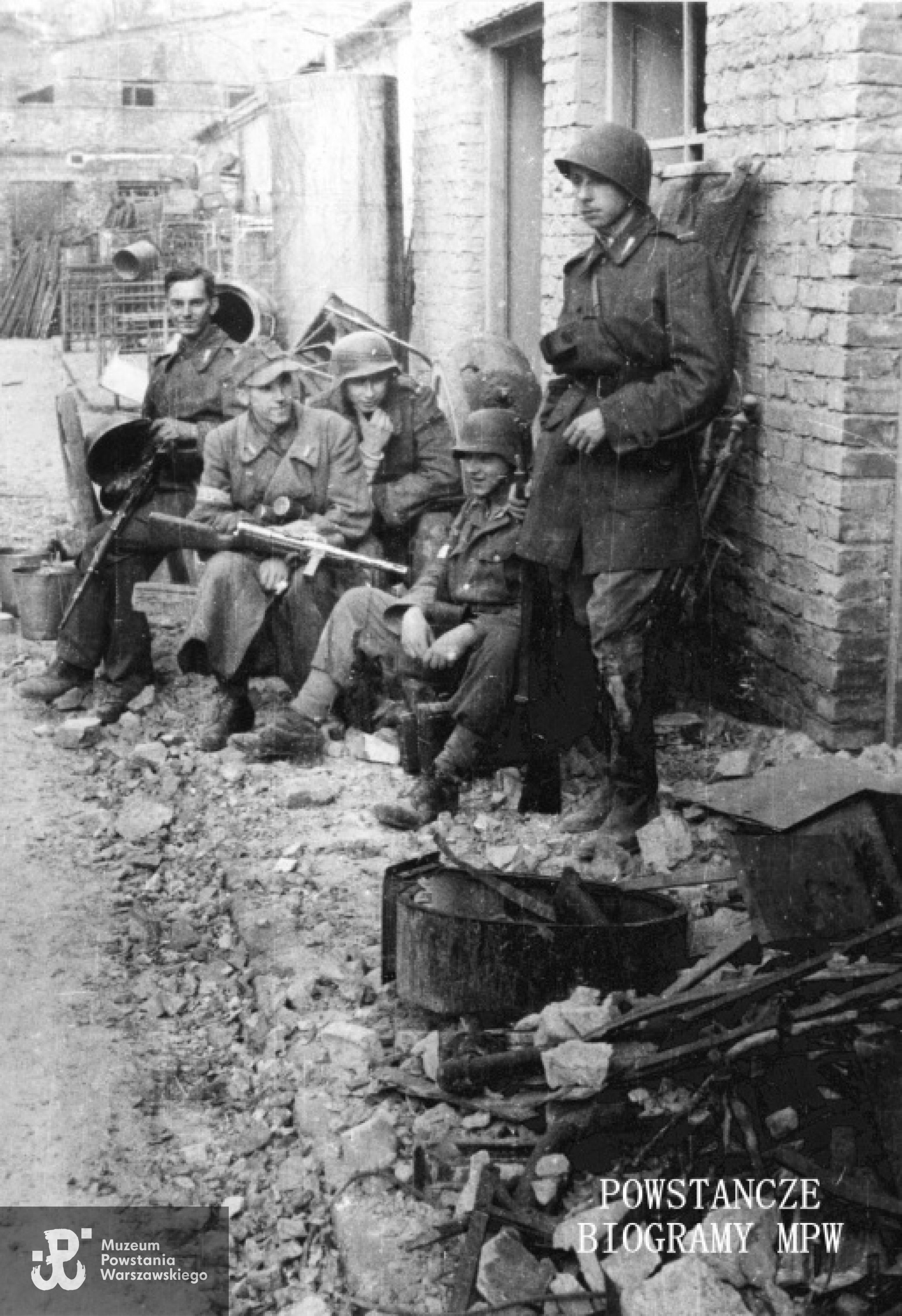 Fotografia z Powstania Warszawskiego. Powstańcy z kompanii "Koszta" na tyłach PAST-y na bazarze Pociejów między ulicami Zielną i Bagno; od prawej: st. strz. Wacław Zajączkowski "Wrona", st. strz. Ludwik Berkowski "Zawisza", st. strz. Wiktor Boryczko "Dzierżak", NN, st. strz. Tadeusz Ostrowski "Teoś". Fotografia autorstwa Eugeniusza Lokajskiego ps. "Brok", sygnatura MPW: MPW-IN/569