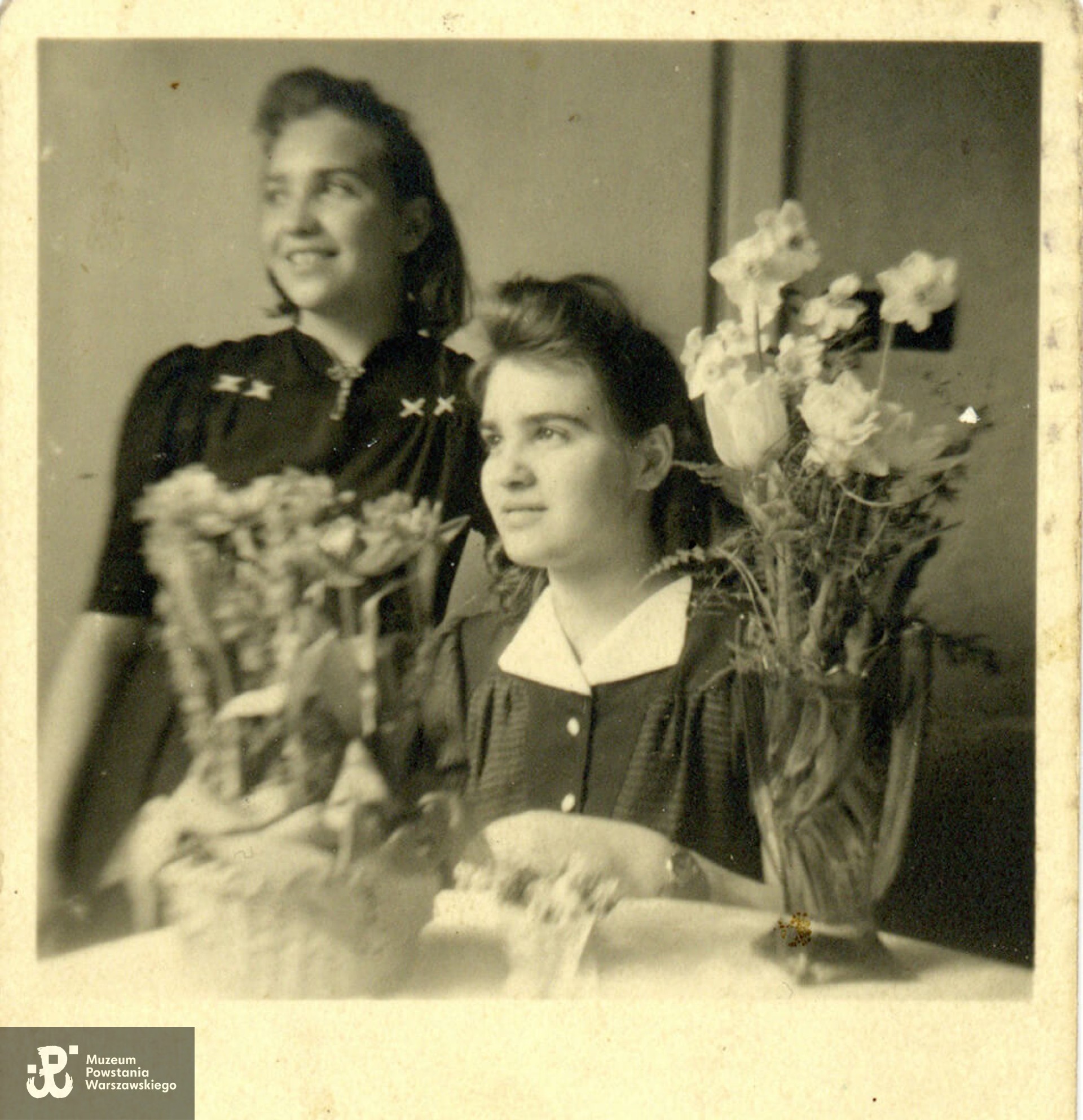 Siostry Sobolewskie - Zofia (z lewej) i Aleksandra (przy stole) tuż przed Powstaniem Warszawskim - fotografia wykonana w maju 1944 roku. Fot. ze zbiorów rodzinnych, udostępniła p. Małgorzata Morawska, córka Zofii Kielar-Sobolewskiej. Skan wykonano w Muzeum Powstania Warszawskiego, 05/2024.