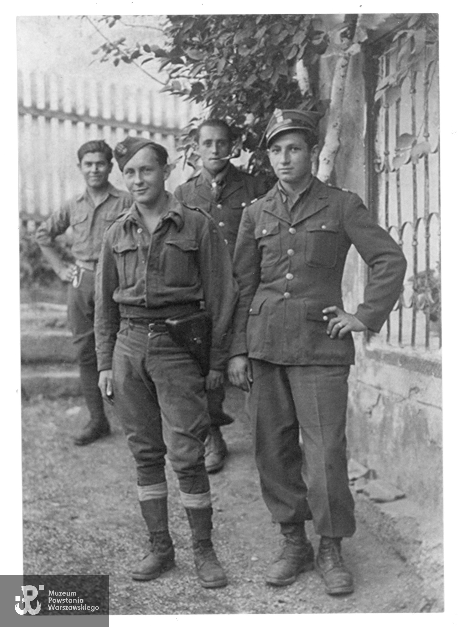 Fotografia wykonana w maju 1945 roku po wyzwoleniu jeńców z niewoli ze Stalagu XVIII C Markt Pongau San Salzburg.  Z tyłu od lewej 1) plut. Kochanowski, żołnierz armii Berlinga, strzelec Biela (Armia Krajowa) - obaj bez czapek), na przedzie: 3) st. strz. Roman Lipiec (AK) i kpr. Woźniak - armia Berlinga. Fot. ze zbiorów Muzeum Powstania Warszawskiego, źr. Teczki personalne uczestników Powstania Warszawskiego, udostępnił p. Roman Lipiec