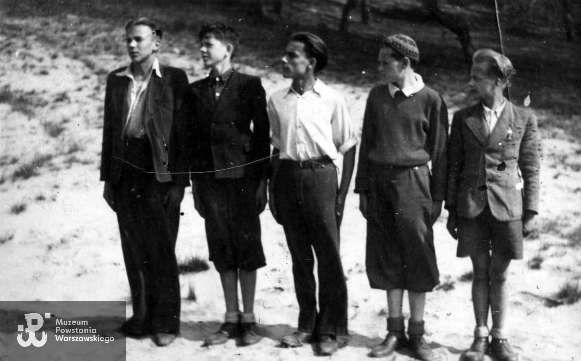 Zastęp Szarych Szeregów w Legionowie podczas zbiórki w terenie. Widoczni od lewej: Sławomir Klejment, Włodzimierz Obojski, Edward Kalinowski, Zbigniew Podgórski, Jerzy Binder. Legionowo 1943-1944. Fotografia ze zbiorów Muzeum Historycznego w Legionowie, MHwL/Zd 77.