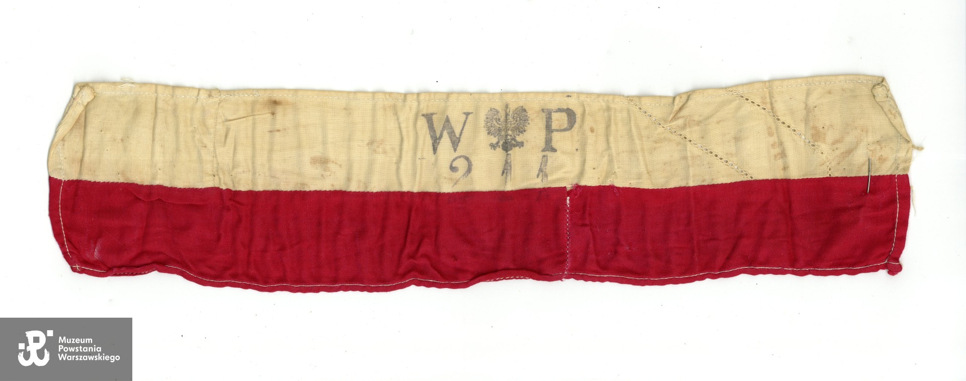 Należąca do Lidii Zwierzchowskiej "Marzeny" opaska biało-czerwona. Ze zbiorów Muzeum Powstania Warszawskiego, przedmiot przekazany przez córkę p. Lidii Zwierzchowskiej  (Konecki), p. Ewę Nowakowski, sygn. P/10128, numer inwentarzowy: MPW-M/3846