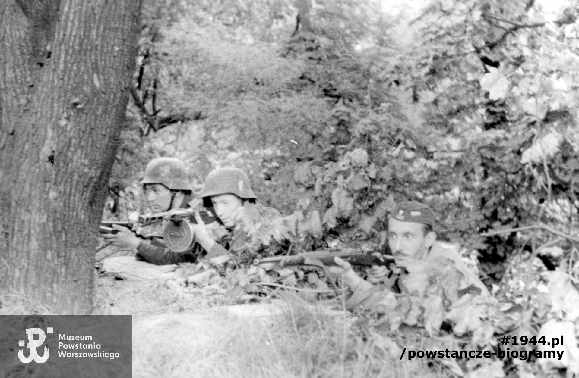 Fotografia z Powstania Warszawskiego. Śródmieście Południowe. Stanowisko na skarpie w ogrodzie szpitala św. Łazarza. Na pierwszym planie powstańcy z batalionu "Miłosz", od lewej: plut. Ryszard Lewandowski "Oporek", kpr. Lech Krasnowolski "Leszek", Wacław Paradowski "Kary" (w furażerce). Fot. ze zbiorów Muzeum Powstania Warszawskiego, sygn. MPW-IK/2357. Autorem zdjęcia jest Wojciech Marczyński "Bogusław"