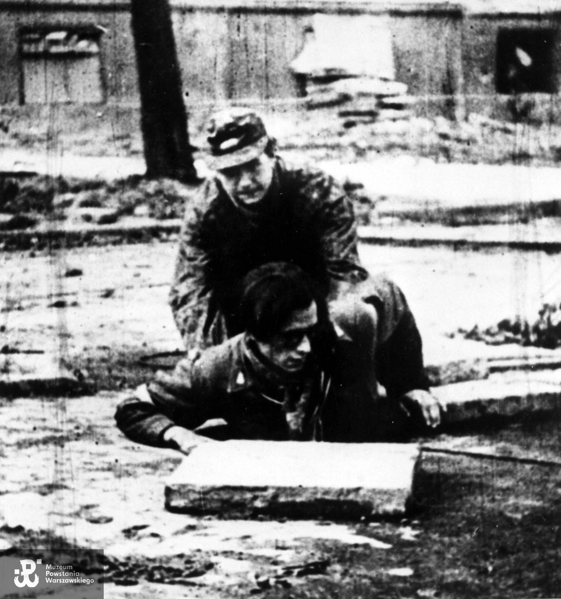 27 września 1944 r.   Fotografia filmowa z Powstania Warszawskiego. Śródmieście Południowe. Żołnierze AK z oddziału szwoleżerów z Mokotowa wychodzą z kanału w Al. Ujazdowskich przy wylocie ul. Wilczej. Z włazu wychodzi Roman Banach - operator powstańczej kroniki. Fot. ze zbiorów Muzeum Powstania Warszawskiego, sygn. MPW-IH/1186