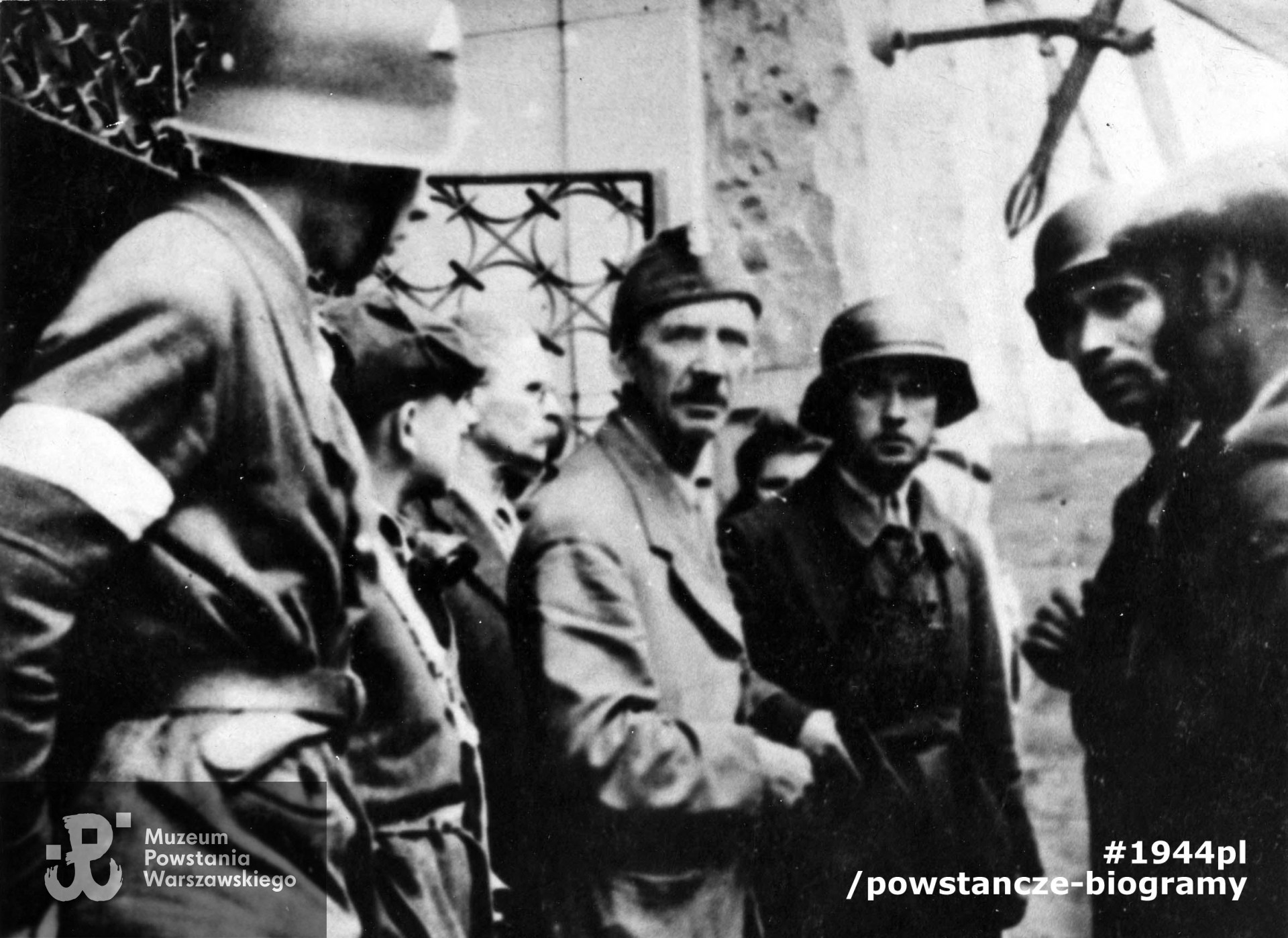 Fotografia z Powstania Warszawskiego. Śródmieście Północne. Żołnierze z oddziału "Leśnika" przed gmachem Sądu Grodzkiego na ul. Ogrodowej. Od lewej kolejno: NN, NN, mjr Adolf Łojkiewicz "Ryś", w furażerce ppłk Jan Szypowski "Leśnik", st. strz Kazimierz Rytel "Kazik", pchor. Marian Gorzkowski "Szary" i Stefan Kowalski "Jaroń" w cyklistówce. Ze zbiorów Muzeum Powstania Warszawskiego, sygn. MPW-IK/1318