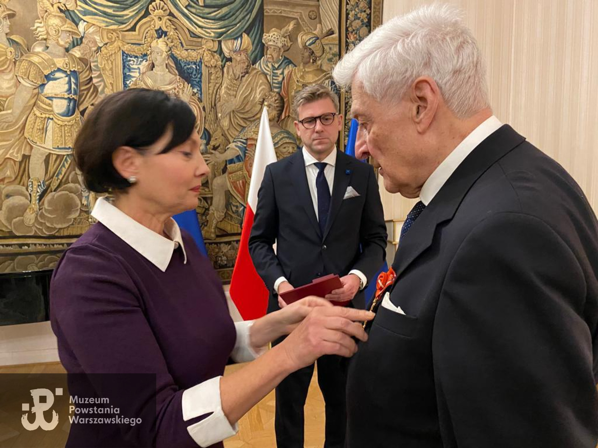 Dekoracja Krzyżem Oficerskim Orderu Odrodzenia Polski, 09.11.2021. Fot. Serwis Rzeczypospolitej Polskiej, domena publiczna, licencja CC BY-NC-ND 3.0 PL, dostęp: <i>https://www.gov.pl/web/szwecja/uroczyste-odznaczenia-dla-powstanca-warszawskiego-i-dzialaczy-solidarnosci</>