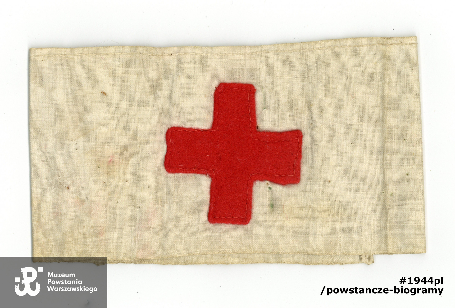 Opaska sanitarna z czerwonym krzyżem należąca do Anny Budzyńskiej z d. Chyckiej. Ze zbiorów Muzeum Powstania Warszawskiego, sygn. P/9308