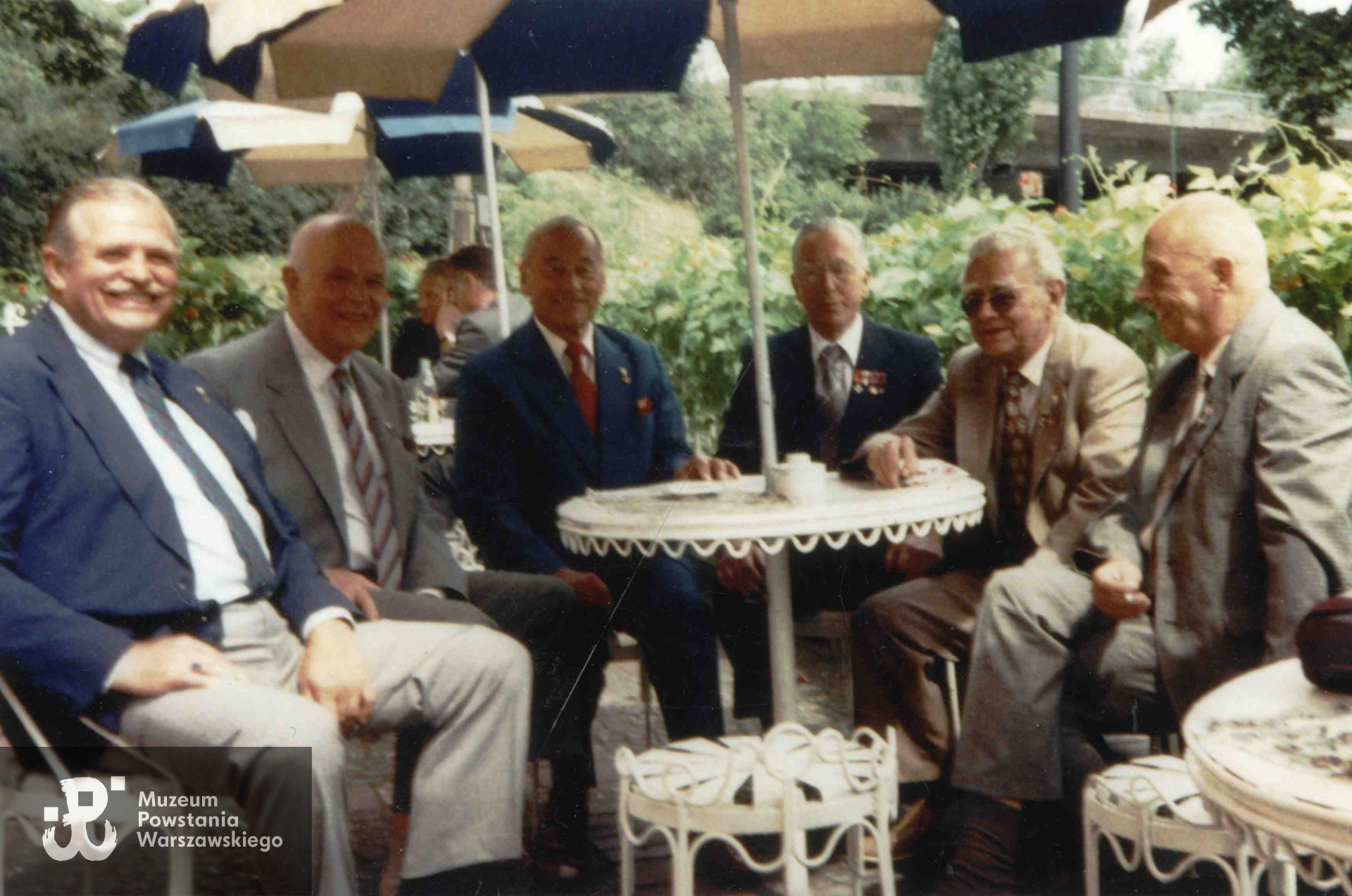 Spotkanie w 50. rocznicę wybuchu Powstania Warszawskiego. Przy kawiarnianym stoliku siedzą byli żołnierze Kompanii Szturmowej "Stefan". Od lewej: strz. Jacek Henneberg "Górzan", kpr. pchor. Andrzej Piekarski "Rola I", NN, kpr. Jan Zawadzki "Happy", kpr. Andrzej Niernssee "Rola II", kpr. pchor. Krystyn Plewko "Krystyn"Fot. ze zbiorów Muzeum Powstania Warszawskiego, sygn. MPW-IP/6363/10 (P/7326/11)