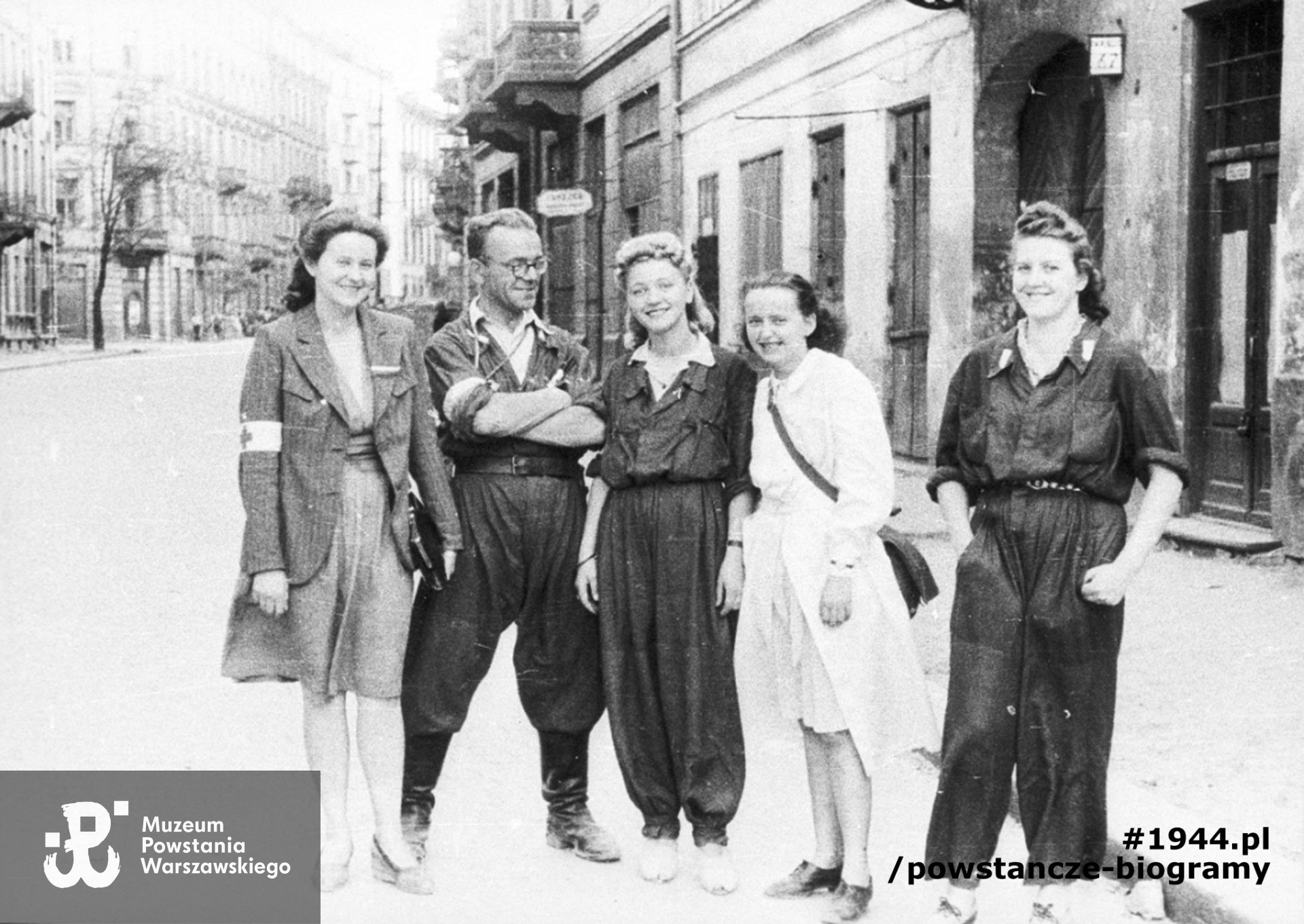 Fotografia z Powstania Warszawskiego. Śródmieście Południowe. Grupa powstańców z 1. plutonu "Kłosa" 3. kompanii "Redy" batalionu "Miłosz" na ulicy Mokotowskiej 67, widok w kierunku południowym. Stoją od lewej: NN, ppor. Henryk Bigajski "Potocki", sanit. Daniela Białowąs "Nutka", strz. Zofia Tomasik "Teresa", Barbara Rau "Basia". Autorem zdjęcia jest Wojciech Marczyński "Bogusław". Fot. ze zbiorów Muzeum Powstania Warszawskiego, sygn.MPW-IH/5912