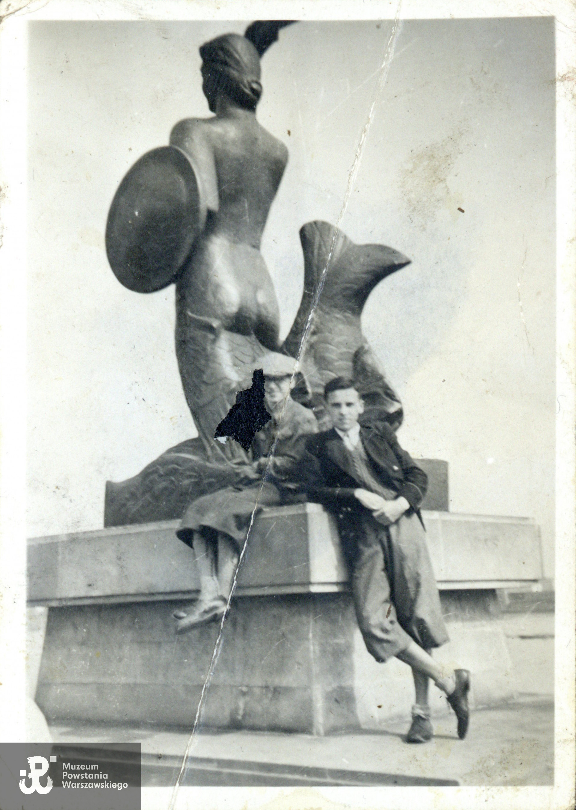 Nad Wisłą przy pomniku warszawskiej Syreny  autorstwa Ludwiki Nitschowej,  Wybrzeże Kościuszkowskie u wylotu ul. Tamka,  okres okupacji niemieckiej. Fot. ze zbiorów rodzinnych,  udostępniły  p. Dorota Zbiegniewska-Lech i p. Anna Zbiegniewska-Lis, siostrzenice Powstańca. Skany wykonano w Muzeum Powstania Warszawskiego w lutym 2024 r. 