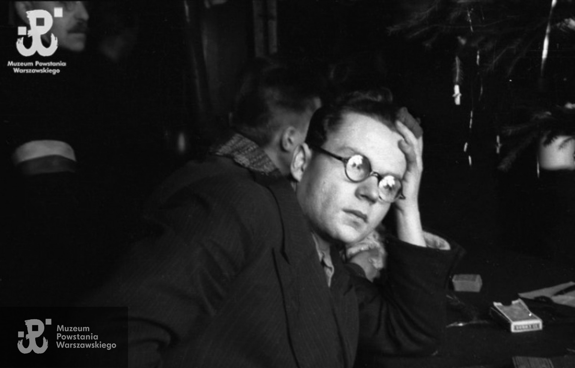 Ppor. Henryk Ożarek „Henio”, z kompanii "Anna" Batalionu "Gustaw" przy stole w baraku nr 198 - 24 - 26 grudnia 1944 r. Fot. Wiesław Chrzanowski „Wiesław”, ze zbiorów Fototeki MPW, sygn. MPW-IN/3383