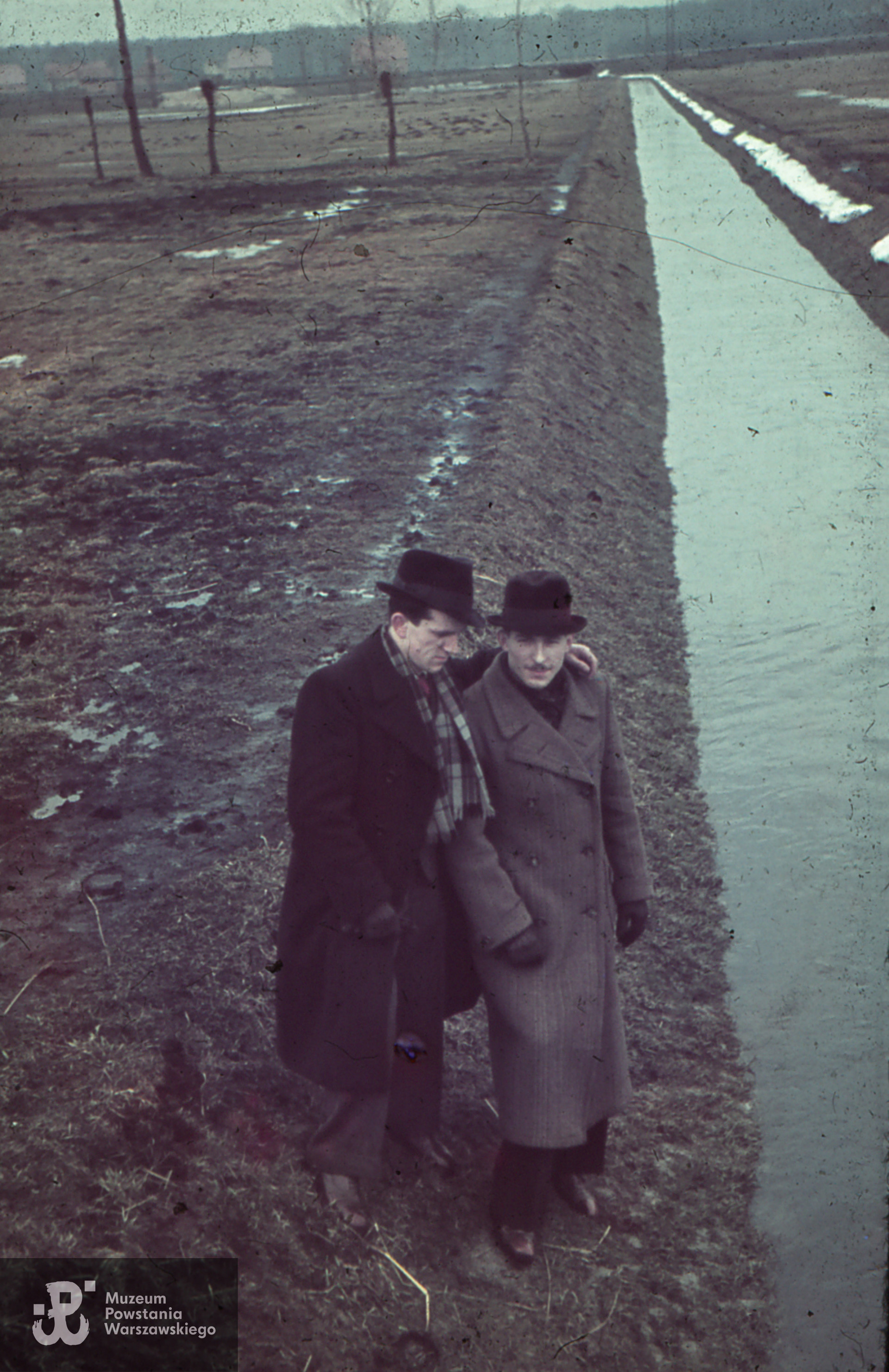 Fotografia wykonana przed udaniem się do Warszawy, ok. 1940 (?)  roku. Według informacji przekazanych przez pana Andrzeja Kamińskiego, kolorowy slajd przedstawia jego stryja (po lewej stronie) z kolegą nad Ołobokiem w Ostrowie Wielkopolskim. Pan Andrzej napisał, że "zdjęcie zostało zrobione na pewno po 1940 r. a przed 1942 r. kiedy Tadziu uciekł do Warszawy w 1942 r.,a kolorowe slajdy były robione od 1940 r na filmach Agfy wysyłanych do wywołania w Berlinie przez p. Eulenfeda, żołnierza AK".  Fot. ze zbiorów rodzinnych udostępnił  p. Andrzej Kamiński, bratanek Tadeusza
