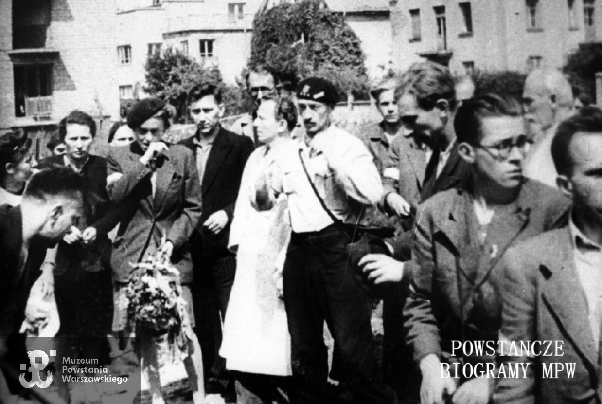 Zdjęcie filmowe z Powstania Warszawskiego autorstwa Romana Banacha ps. "Świerk". Mokotów, cmentarz powstańczy przy Szpitalu Elżbietanek w rogu ulic Goszczyńskiego i Tynieckiej. Grupa powstańców na pogrzebie sanitariuszki Anny Habrowskiej "Marii" z plutonu 1110 dywizjonu "Jeleń". Od lewej z kwiatami sanitariuszka Alina Ciembroziewicz-Zabiełło "Alina". W środku w berecie rtm. Lech Głuchowski "Jeżycki" dowódca "Jelenia", profilem kpr. pchor. Andrzej Bontemps "Mnich", w okularach st. ułan pchor. Andrzej Czernik "Cebion" Fot. ze zbiorów Muzeum Powstania Warszawskiego, sygn. MPW-IH/1224