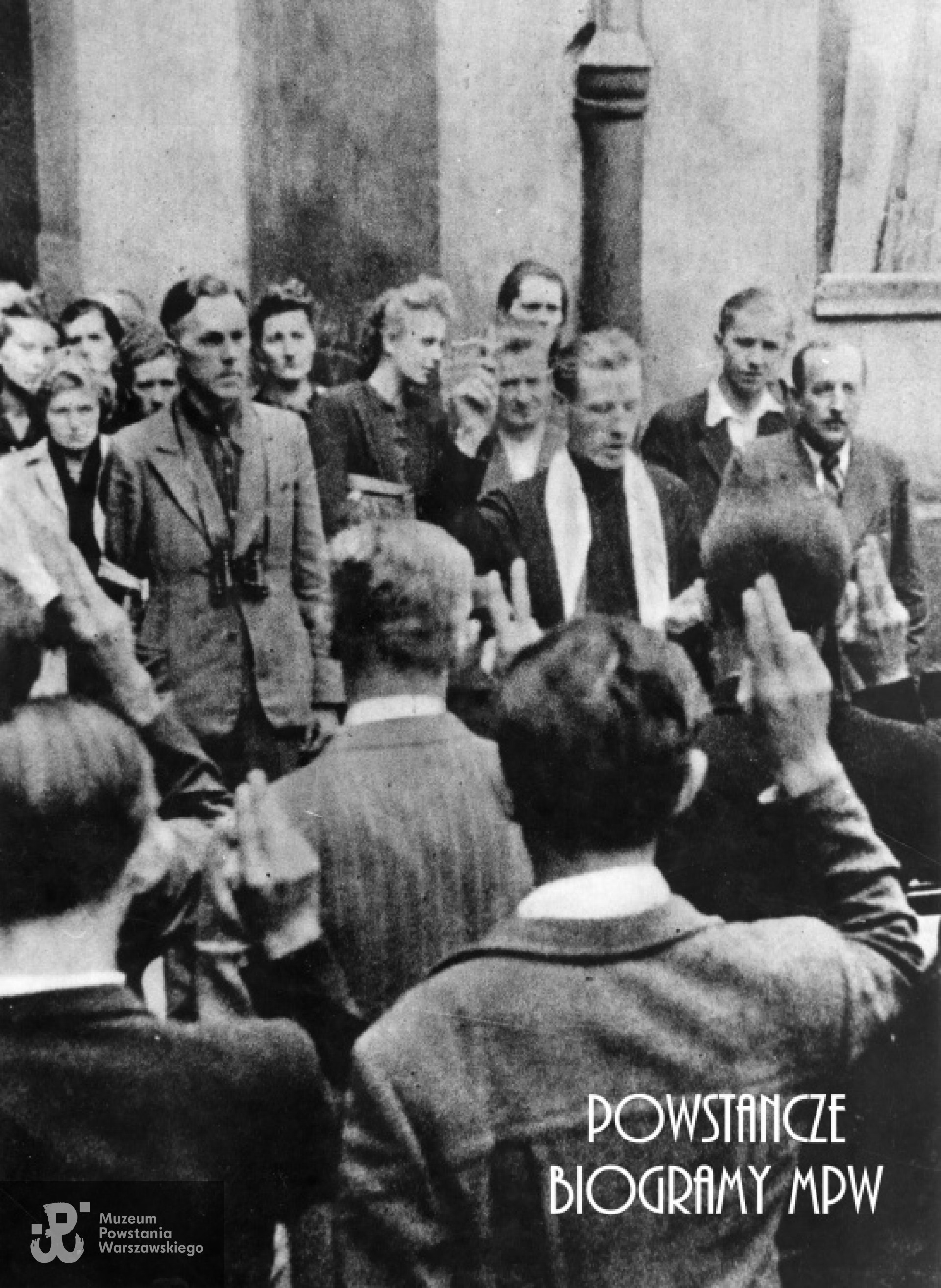 Fotografia z Powstania Warszawskiego. Powiśle. Przysięga ochotników wstępujących w szeregi Armii Krajowej. Na zdjęciu widoczni  por. "Pobóg" (Marian Mieczysław Malinowski) i ks. kapelan Jan Wojciechowski  "Korab". Fot. ze zbiorów Muzeum Powstania Warszawskiego, sygn. MPW-IK-1595