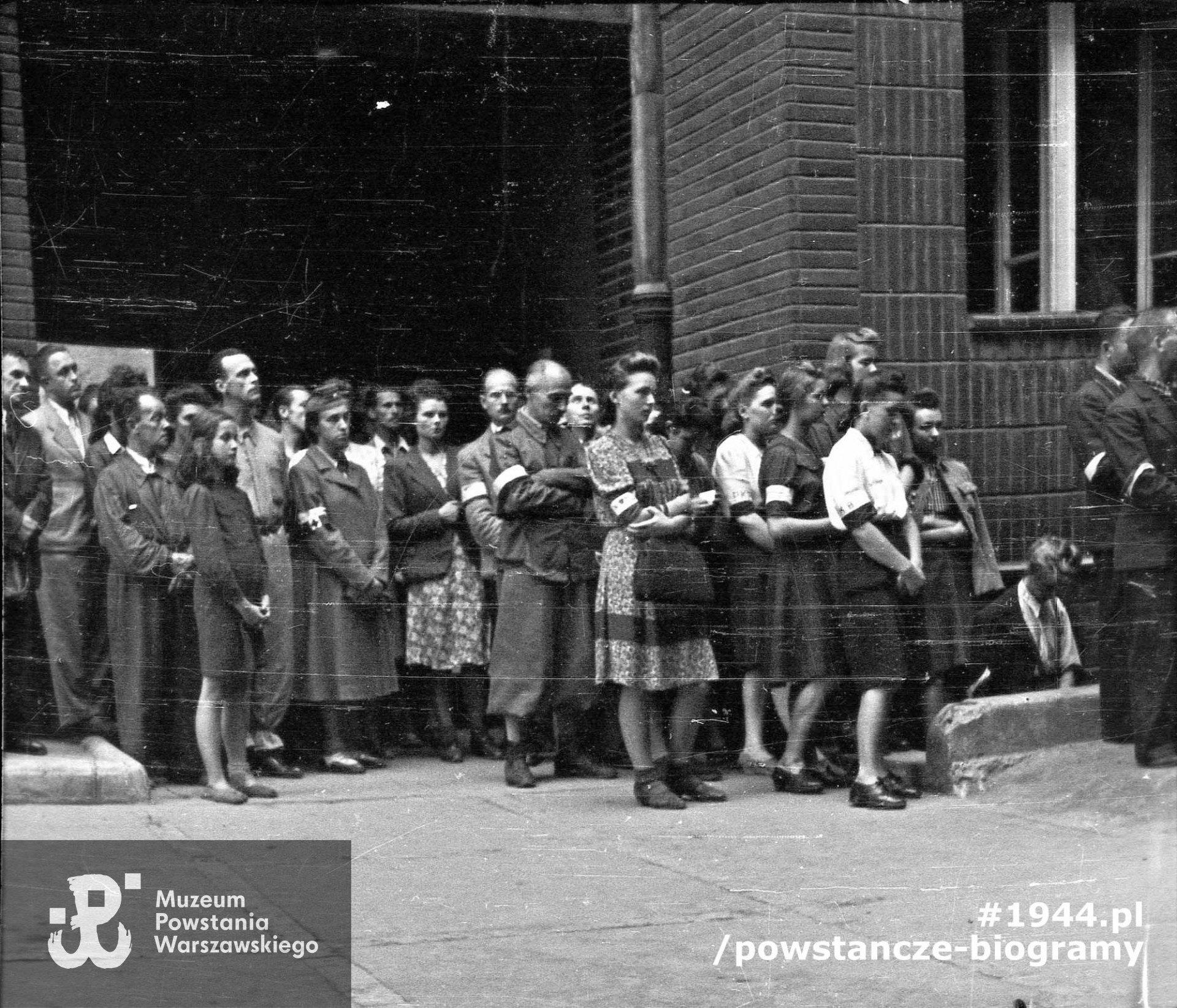 Fotografia z Powstania Warszawskiego. Msza polowa w podwórzu budynku przy ulicy Poznańskiej 12, kwaterze dowództwa zgrupowania "Zaremba" i kompanii "Witolda". Autorem zdjęcia jest Stanisław Dobrzyński. Fot. ze zbiorów Muzeum Powstania Warszawskiego, sygn. MPW-IH/1823