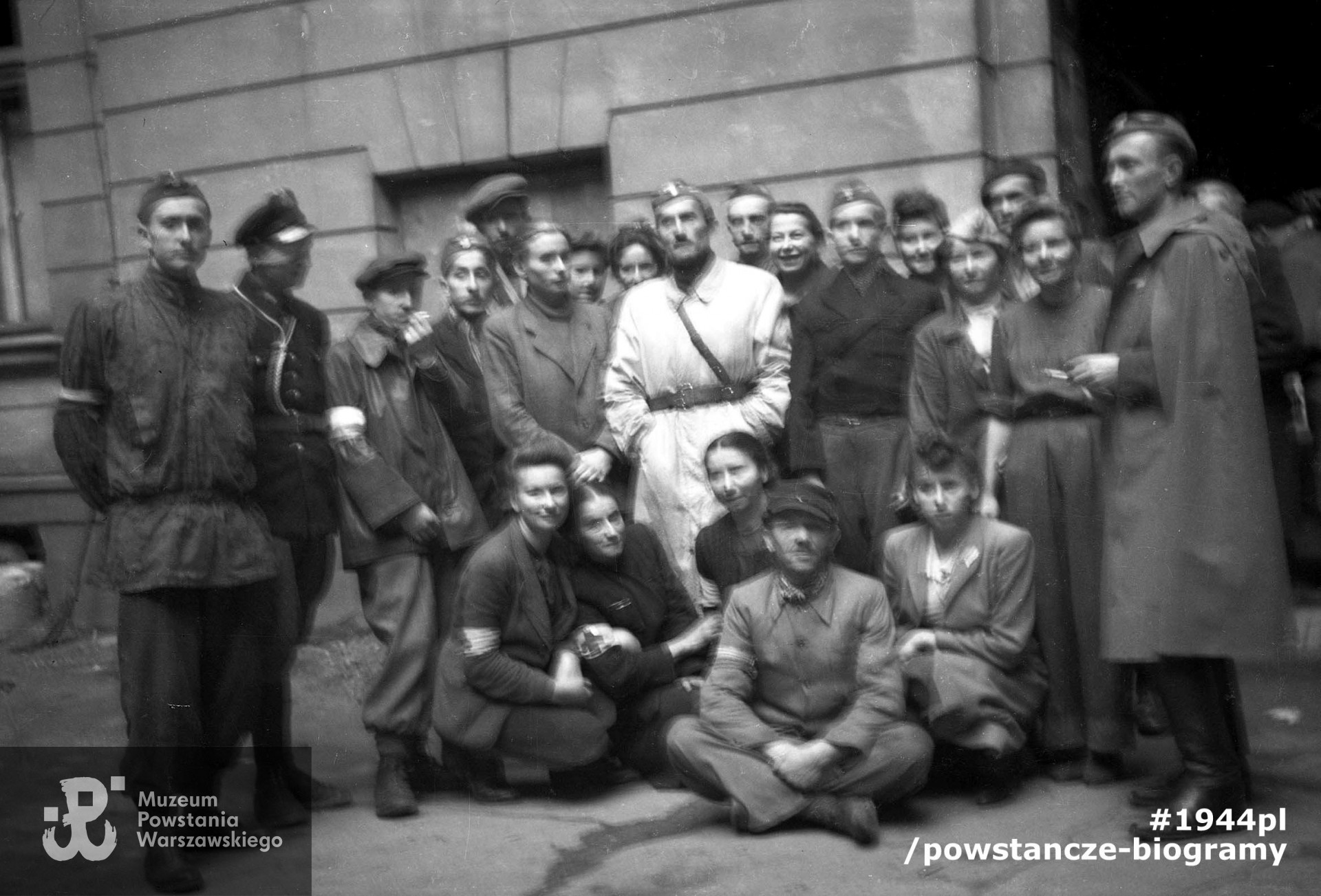 Fotografia z Powstania Warszawskiego. Powiśle. Grupa powstańców ze zgrupowania"Krybar" na podwórzu kamienicy przy ulicy Tamka. Według odręcznej notatki darczyńcy na rewersie, fotografia przedstawia żołnierzy 4 plutonu 9 kompanii. Fot. ze zbiorów Muzeum Powstania Warszawskiego, sygn. P/4980-4, dar p. Kazimierza Ruppa ps.  "Dobiecki". Ujęcie tożsame: MPW-IN/3692(P/5115/06 - zbiór Kazimierza Ruppa).