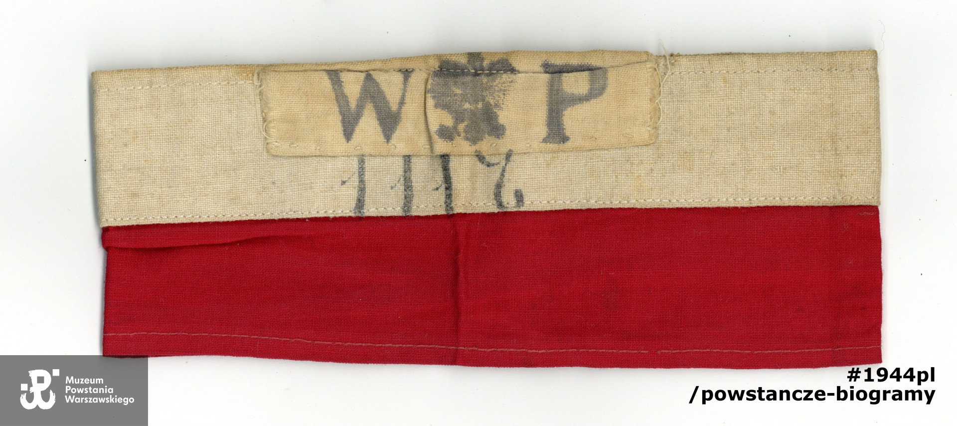 Należąca do Zbigniewa Sznage ps. "Rozmaryn" opaska biało-czerwona z nadrukiem "WP", orzełkiem oraz numerem "1117" (numer na opasce jest numerem 3 kompanii "Wkra"). Ze zbiorów Muzeum Powstania Warszawskiego, sygn. P/9362/20, dar p. Marka Zbigniewa Sznage, wnuka 