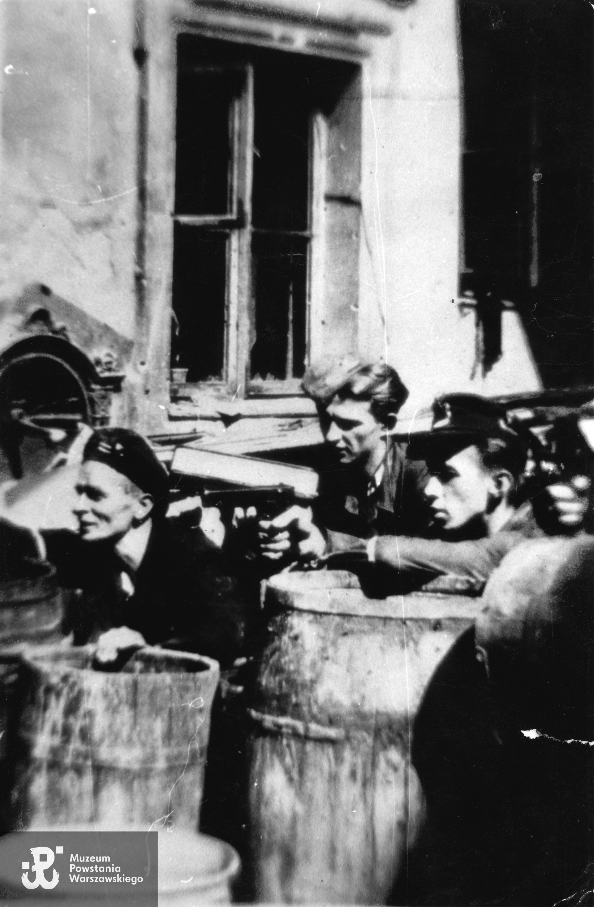 Powstanie Warszawskie. Henryk Junczyk "Sokół III" (na zdjęciu drugi z lewej),  na barykadzie przy ul. Hożej 65.  Fotografia  z archiwum rodzinnego wnuka, obecnie w zbiorach Muzeum Powstania Warszawskiego, sygn. P/8462/16, dar Jana Radziukiewicza 