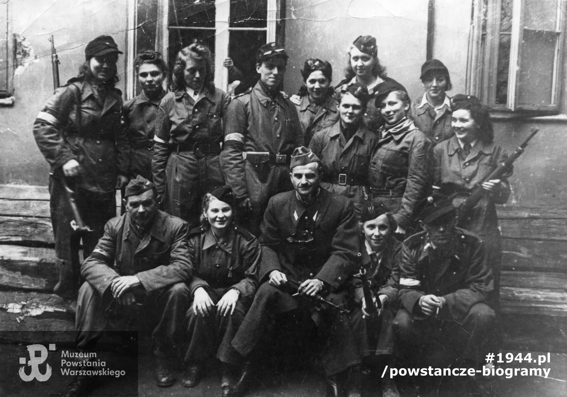 Fotografia z Powstania Warszawskiego, prawdopodobnie sierpień 1944. Oddział kpt. Henryka Więcka „Jura” na podwórzu kamienicy (lokalizacja nieznana). Fot. ze zbiorów Muzeum Powstania Warszawskiego, sygn. MPW-IP/5459. Widoczni na zdjęciu: kpt. Henryk  Więcek „Jur” - siedzący w pierwszym rzędzie, w środku, obok niego Zofia Malinowska „Jaskółka„ (druga z lewej strony). Identyfikacja osób na zdjęciu - p. Jan Bąk ”Złoty", 2019/2020 r.