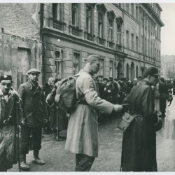 Fotografia z Powstania Warszawskiego. Zbiórka Powstańców przed wyjściem do niewoli. Na pierwszym planie m.in. kpt. Eugeniusz Konopacki 