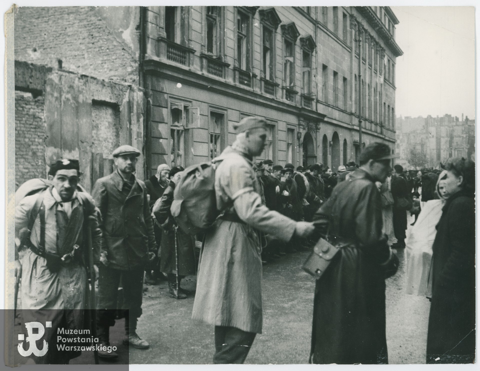 Fotografia z Powstania Warszawskiego. Zbiórka Powstańców przed wyjściem do niewoli. Na pierwszym planie m.in. kpt. Eugeniusz Konopacki "Trzaska" i por. Franciszek Kazimierz Ławruszczuk "Czarny Franek". Fot. ze zbiorów Muzeum Powstania Warszawskiego, sygn. MPW-IV/2375 (P/9401/20)