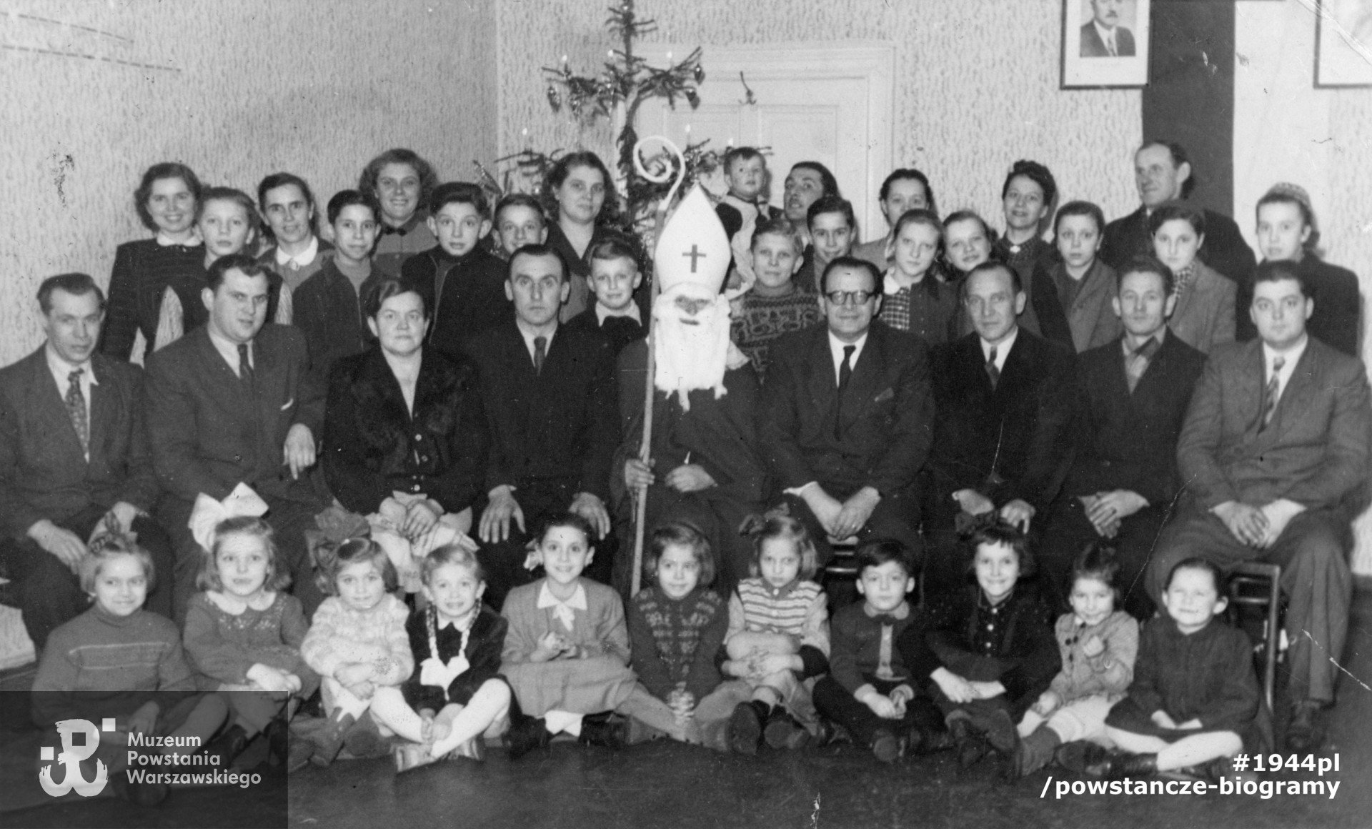 Fotografia powojenna. Spotkanie choinkowe zorganizowane dla dzieci pracowników rozlewni piwa w Bytomiu. Franciszek Hamankiewicz siedzi obok Mikołaja. 1954 lub 1955 rok. Fot. ze zbiorów rodzinnych, udostępniła p. Barbara Bańska