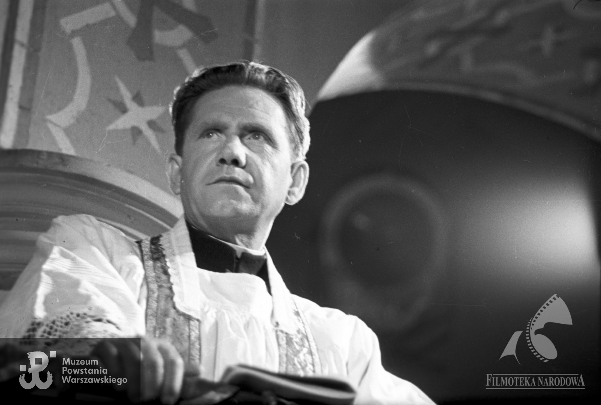Julian Składanek w roli księdza w filmie "Pożegnanie z diabłem" (1956). Fotografia ze zbiorów Filmoteki Narodowej - Instytut  Audiowizualny <strong><i> fototeka.fn.org.pl</i></strong>.