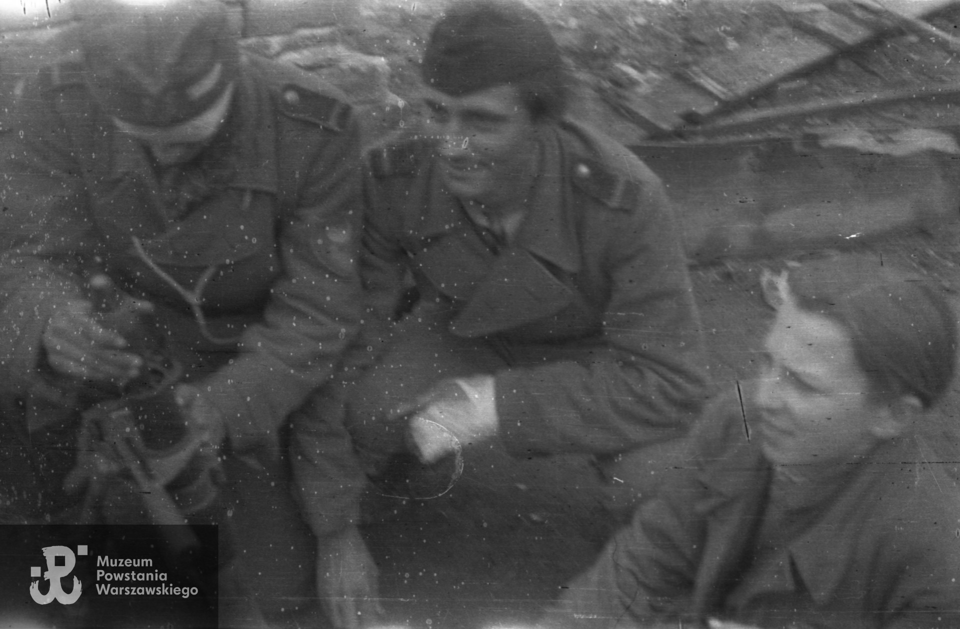Fotografia z Powstania Warszawskiego. Ogrody Instytutu Głuchoniemych i Ociemniałych przy placu Trzech Krzyży. Od lewej: NN, st. strz. Franciszek Świerczewski ”Franuś„, strz. Tadeusz Rajszczak ”Maszynka„.  Autorem zdjęcia jest Jerzy Michalski "Korczak". Fot. ze zbiorów Muzeum Powstania Warszawskiego, sygn.  MPW-IN/4236 (P/4999/06).
