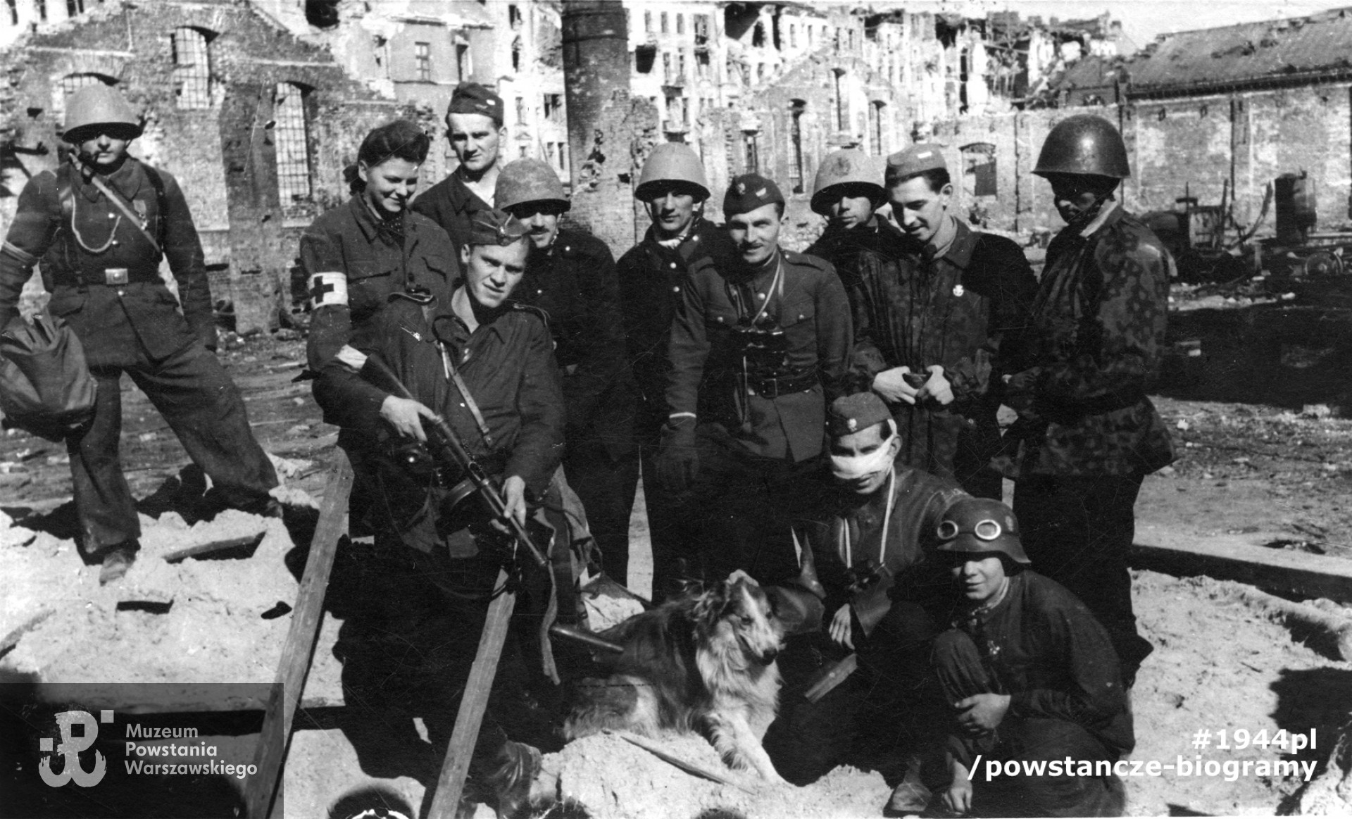 Fotografia z Powstania Warszawskiego. Śródmieście Północne. Powstańcy z III plutonu 2 kompanii I batalionu "Lecha Żelaznego" Zgrupowania "Chrobry II" z psem na terenie ruin fabryki "Bormann, Szwede i s-ka" przy ul. Srebrnej 16 / Wroniej 1. Ujęcie w kierunku północnym. W środku z lornetką dowódca sierż. pchor. Bogdan Łuczyński "Kmicic"Fot. ze zbiorów Muzeum Powstania Warszawskiego, sygn. P/7857-001. Ujęcie tożsame: MPW-IK/1924
