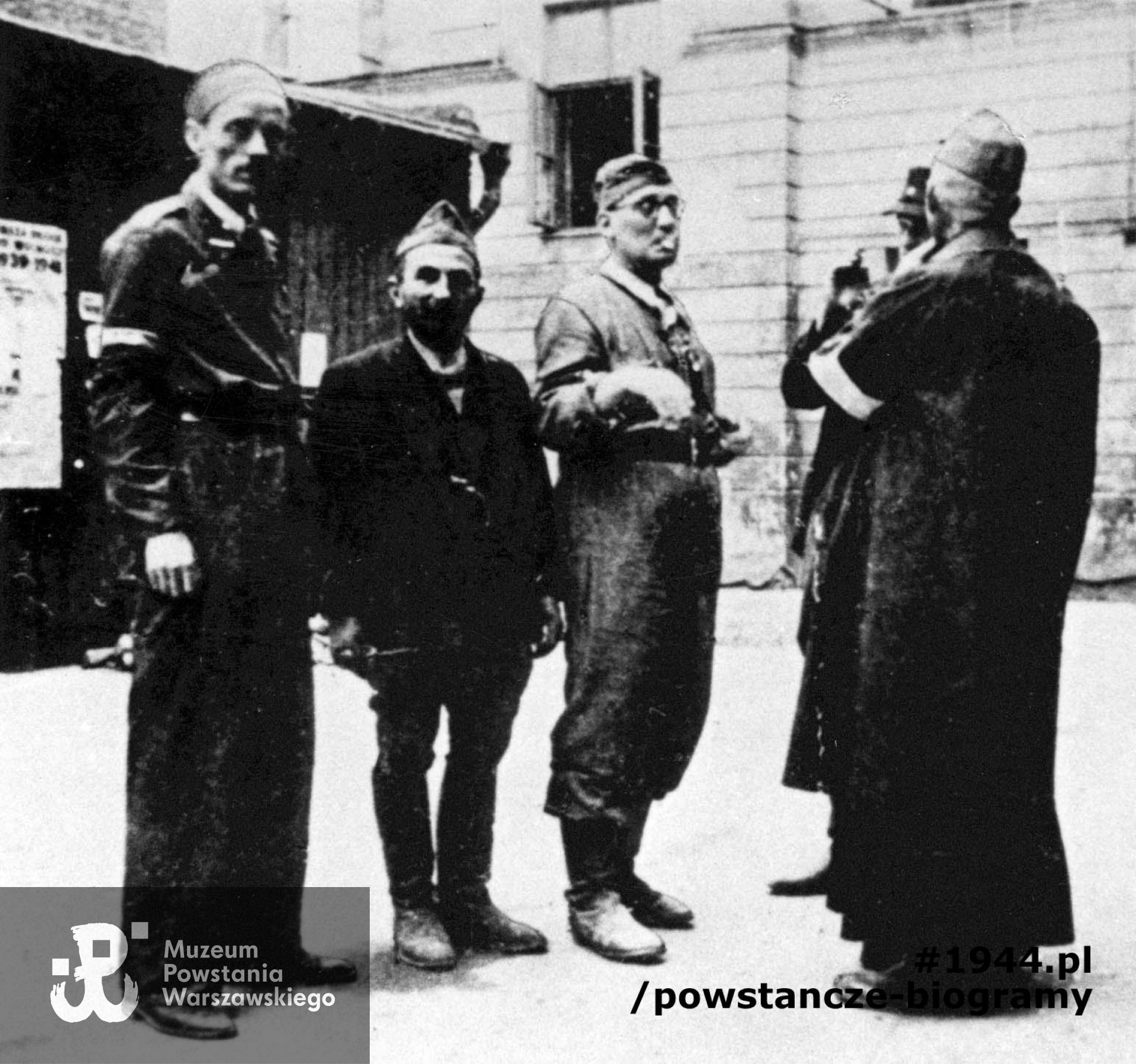 Fotografia z Powstania Warszawskiego. Śródmieście Północne. Dowództwo Zgrupowania "Gurt" na podwórzu kamienicy. Od lewej: st. strz. Zdzisław Sadowski "Pingwin", sierż. Bolesław Ciężar "Zemsta" ochotnik,  kpt. Henryk Kotowski "Kot" oficer saperów, kpt. Leonard Bukłowski "Dworski”, „Feliks", mjr ks. Jan Skrzeczkowski "Jawor" (?)". Fot. ze zbiorów Muzeum Powstania Warszawskiego, MPW-IH/1556 // MPW-IP/3286